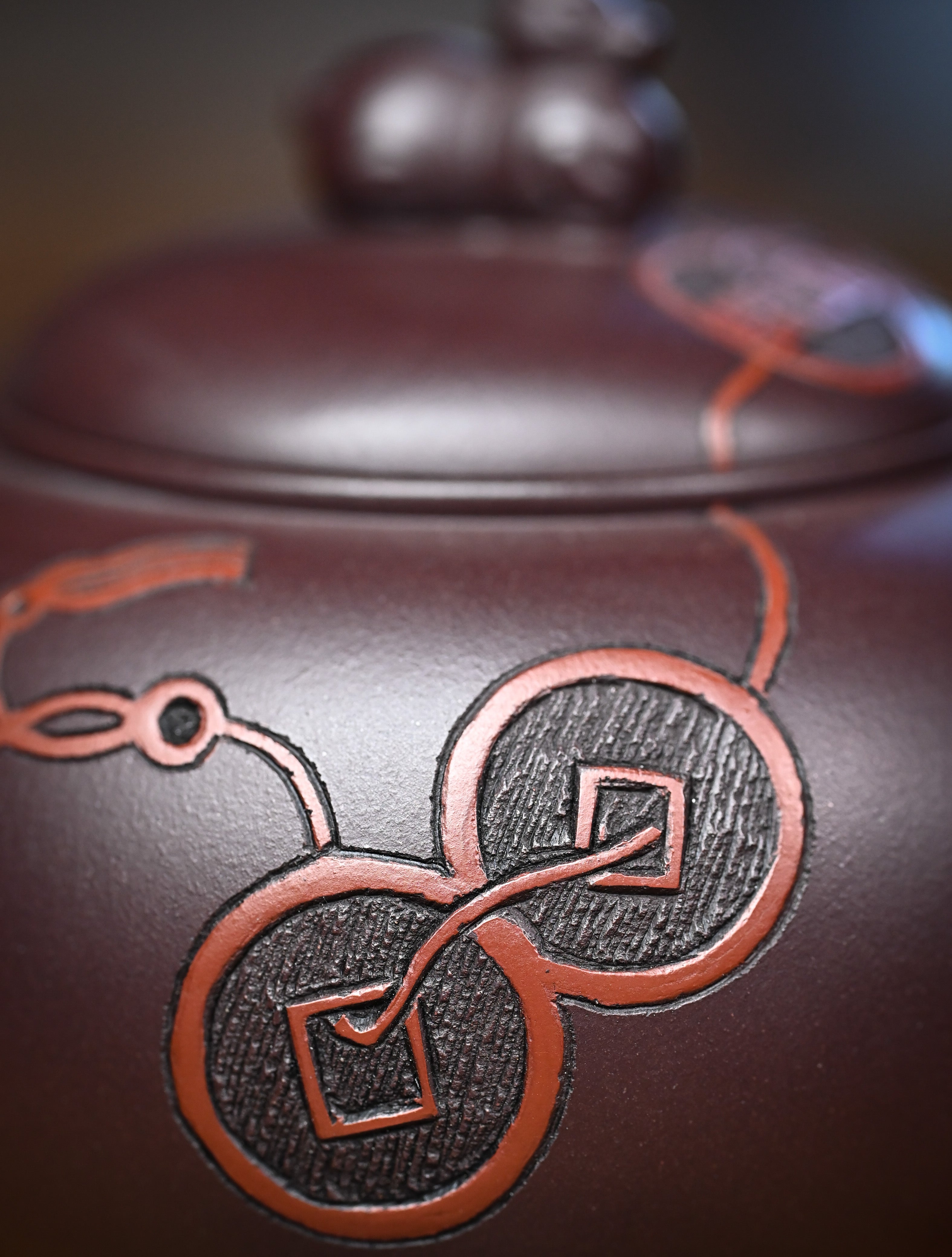 YANYOO handmade Yixing teapot featuring Zini clay and ancient Chinese coin sculpture, lifestyle detail front side.
