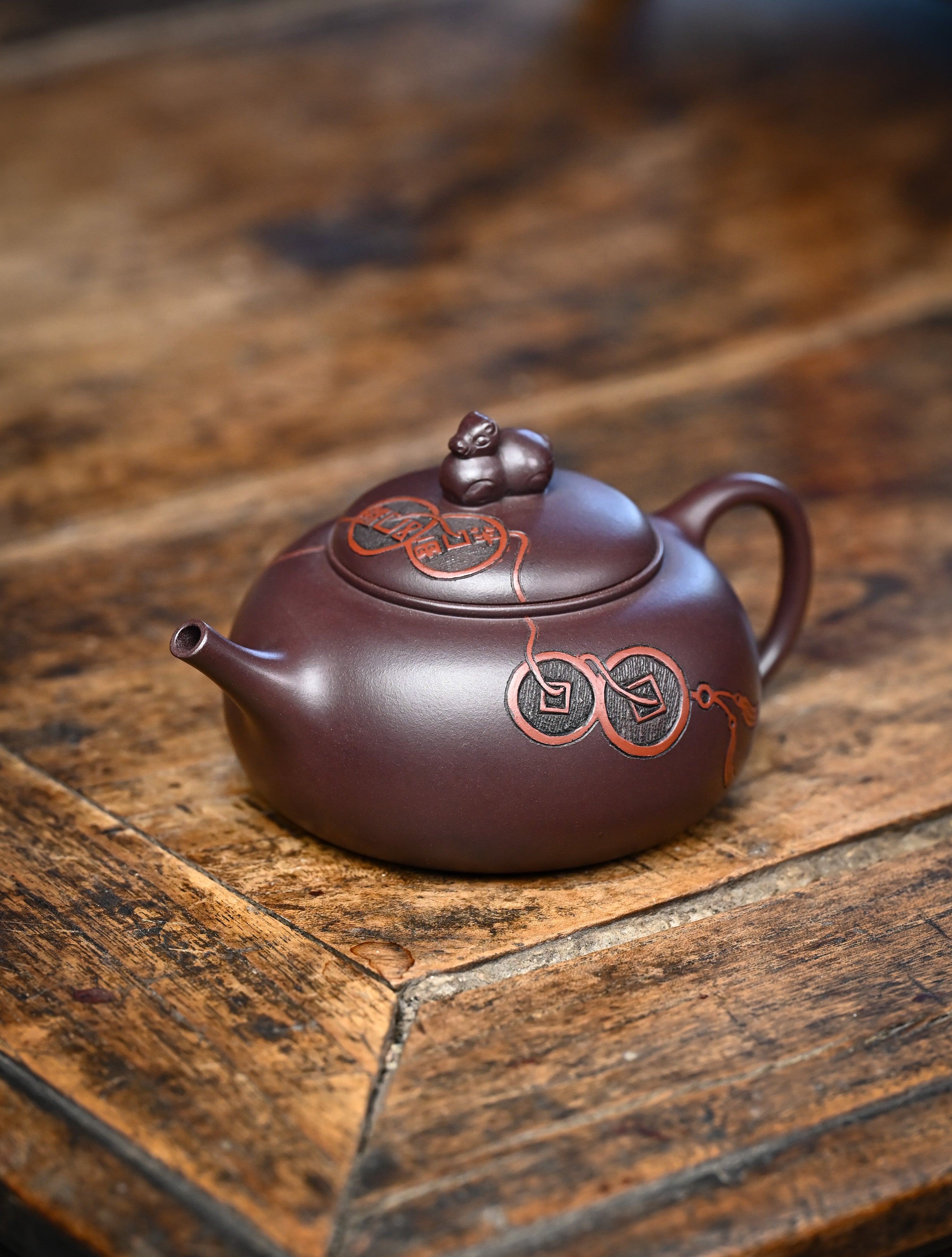 YANYOO handmade Yixing teapot featuring Zini clay and ancient Chinese coin sculpture, lifestyle left side.