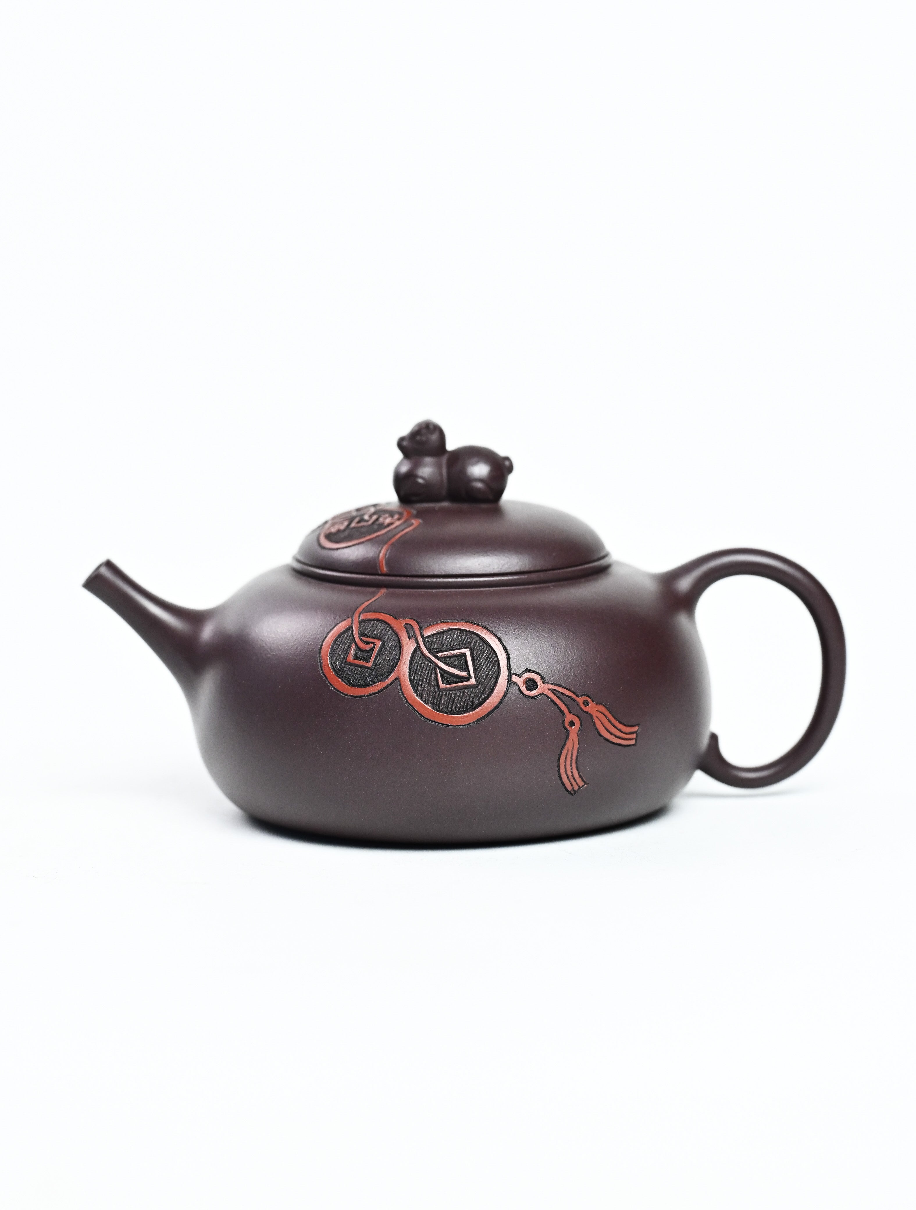 YANYOO handmade Yixing teapot featuring Zini clay and ancient Chinese coin sculpture, product left side.