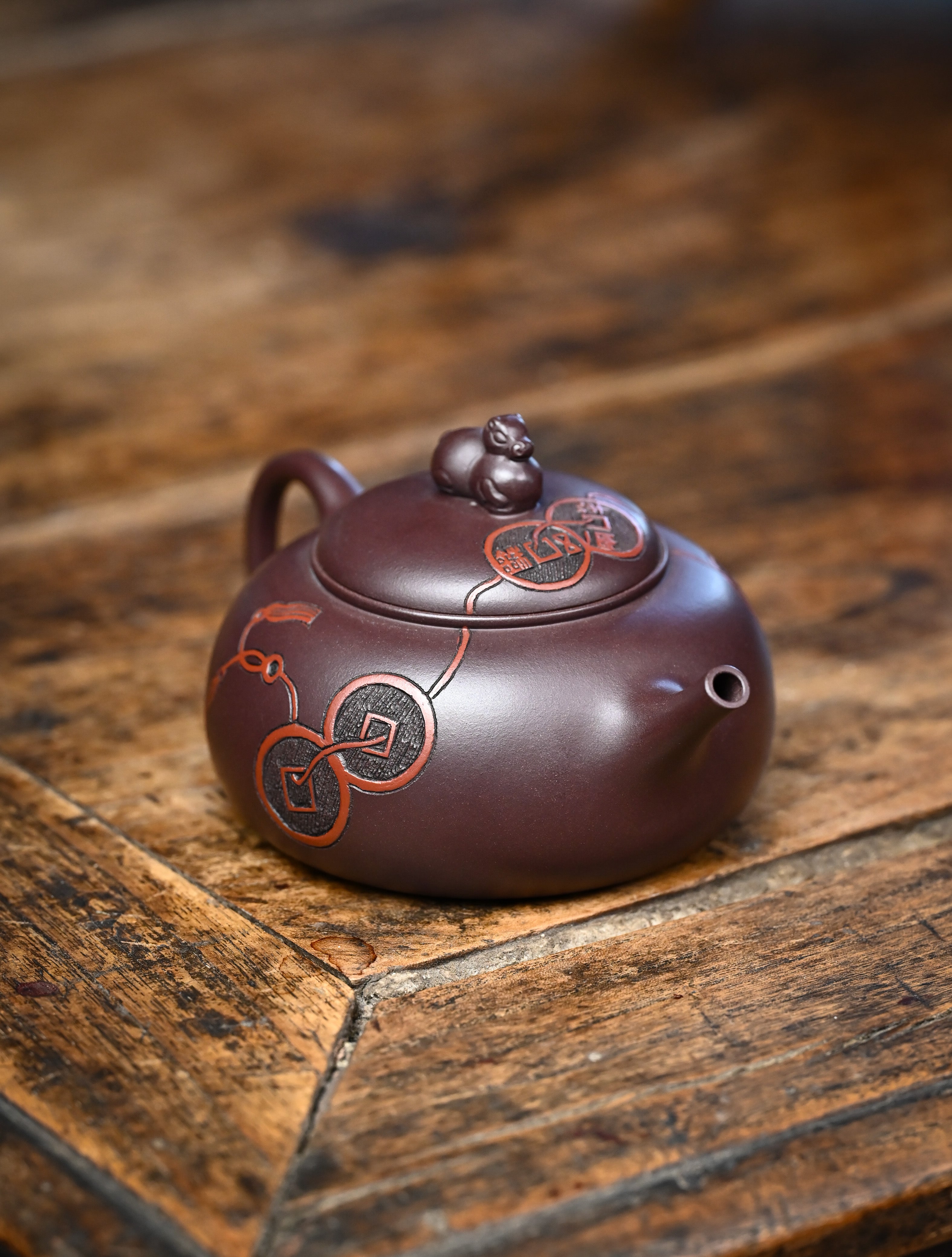 YANYOO handmade Yixing teapot featuring Zini clay and ancient Chinese coin sculpture, lifestyle right side.