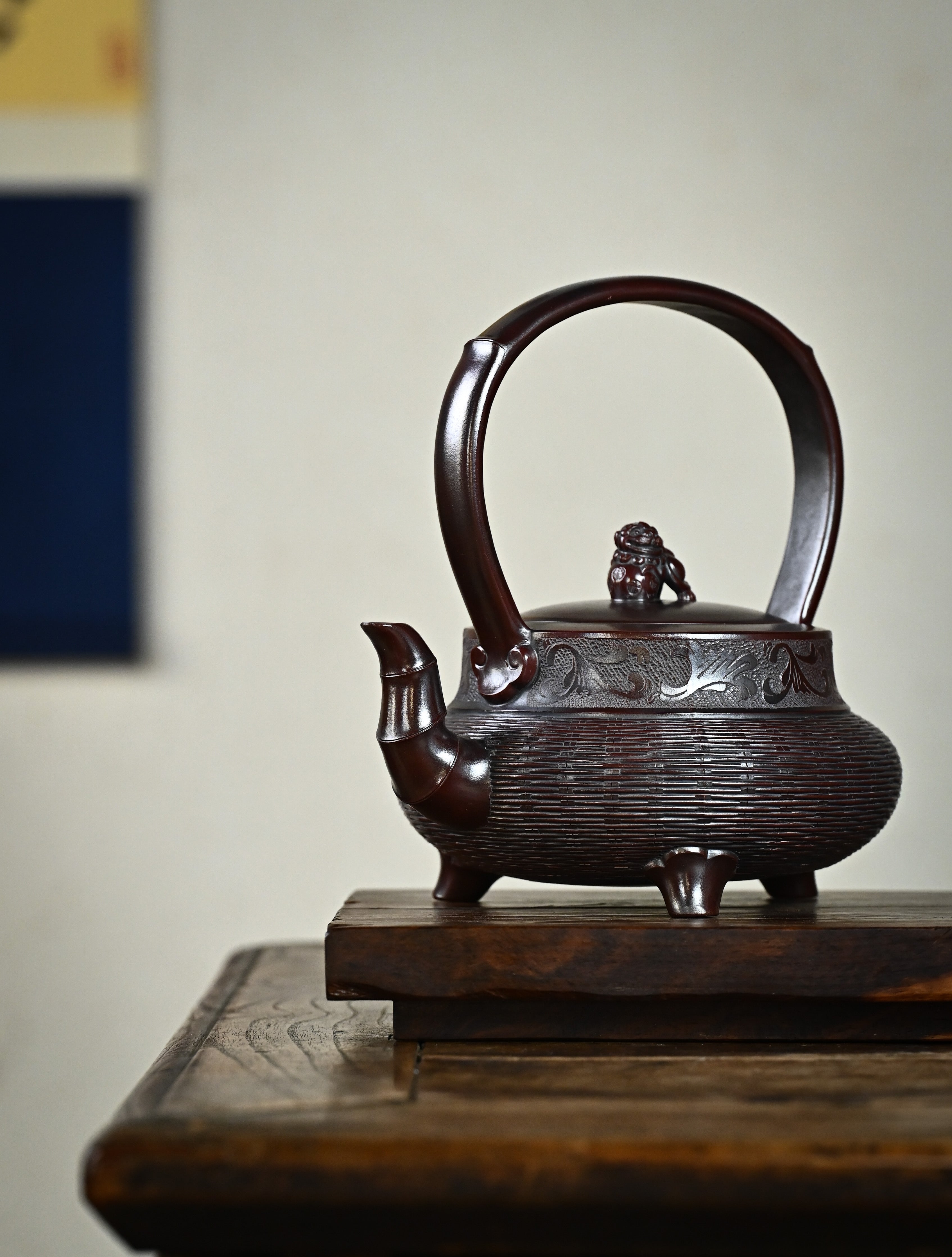 YANYOO handcrafted Yixing teapot featuring aged Wuni clay, bamboo weaving technique and delicate lifting handle, Lifting Tripod, lifestyle front side.