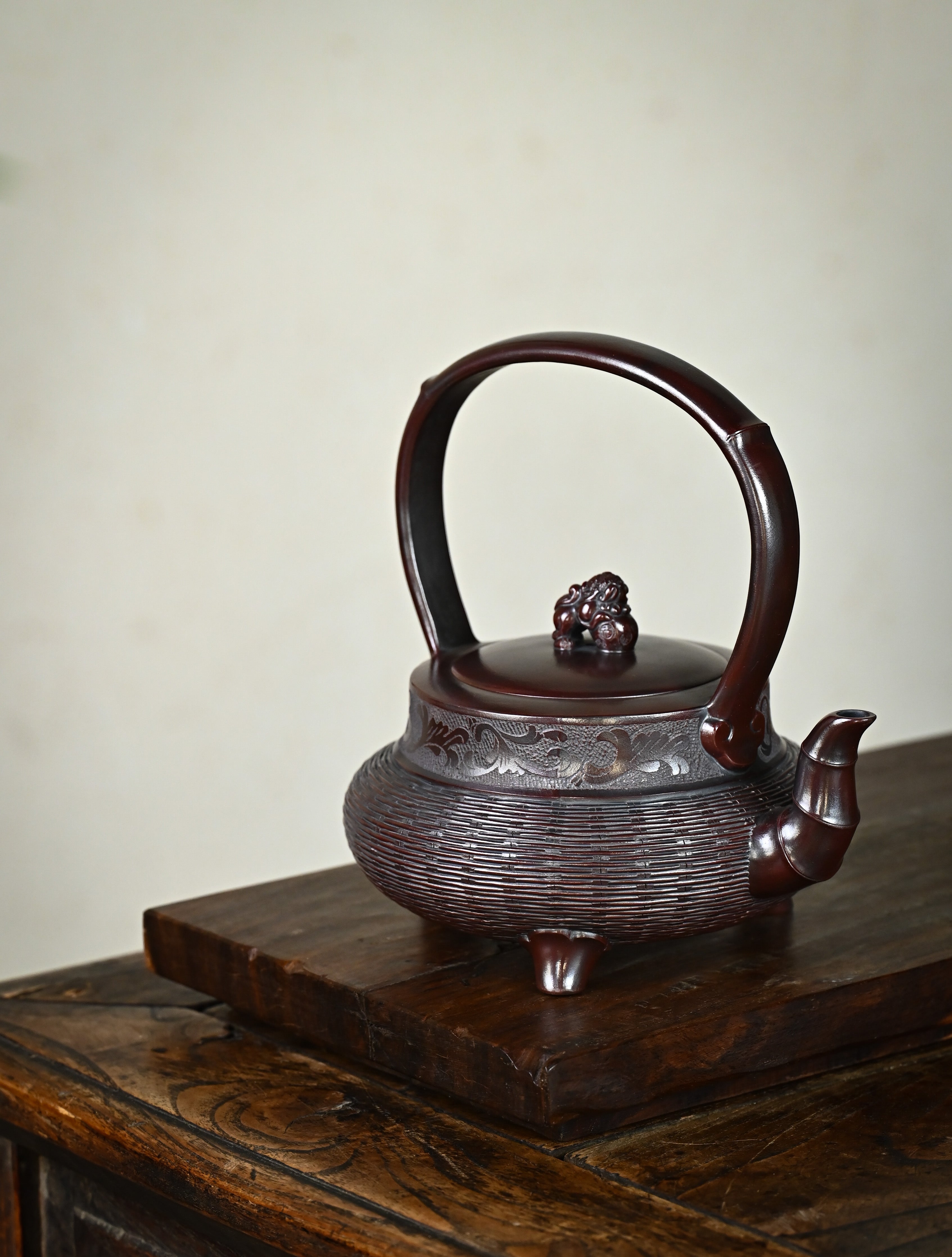 YANYOO handcrafted Yixing teapot featuring aged Wuni clay, bamboo weaving technique and delicate lifting handle, Lifting Tripod, lifestyle right side.