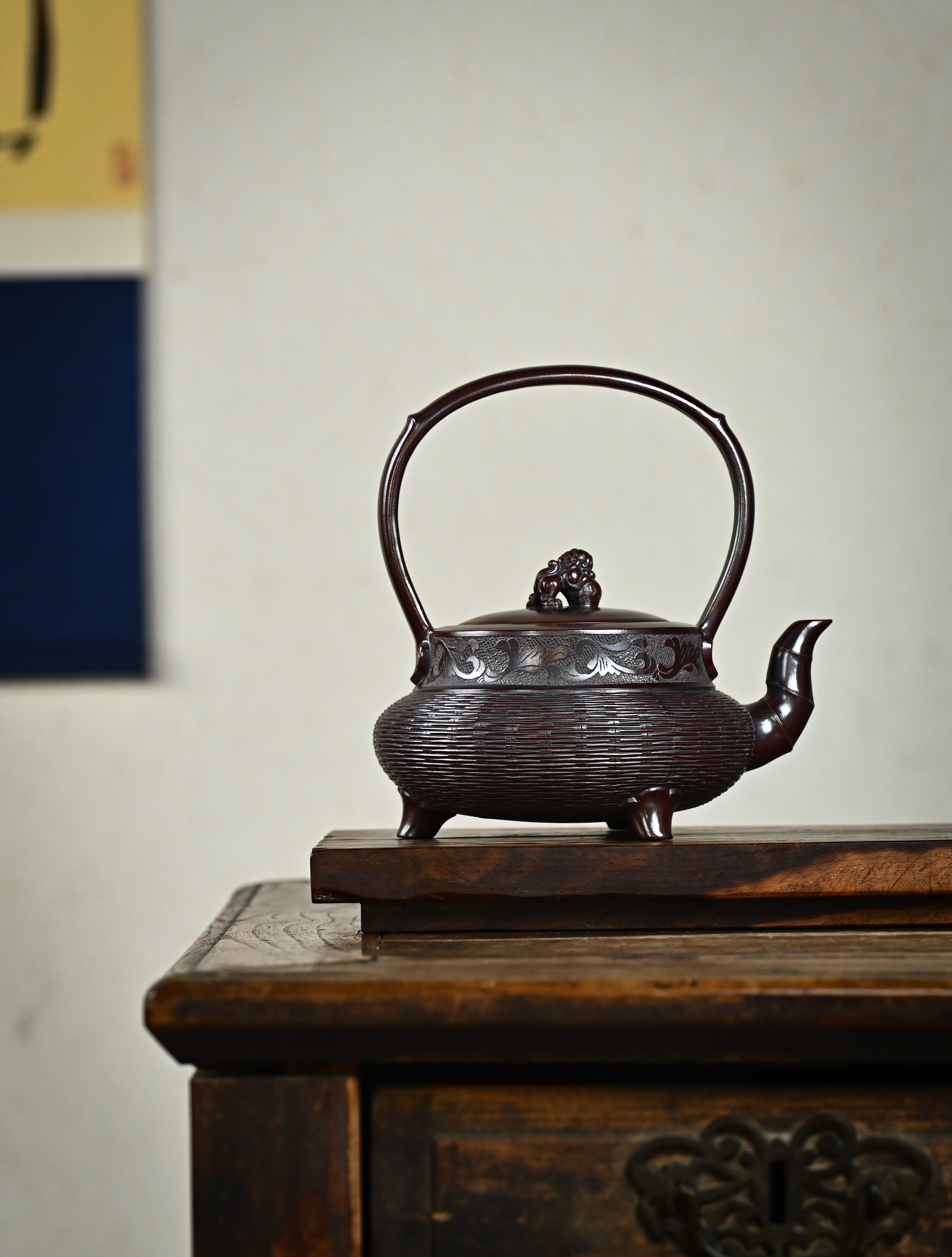YANYOO handcrafted Yixing teapot featuring aged Wuni clay, bamboo weaving technique and delicate lifting handle, Lifting Tripod, lifestyle wide-angle right side.