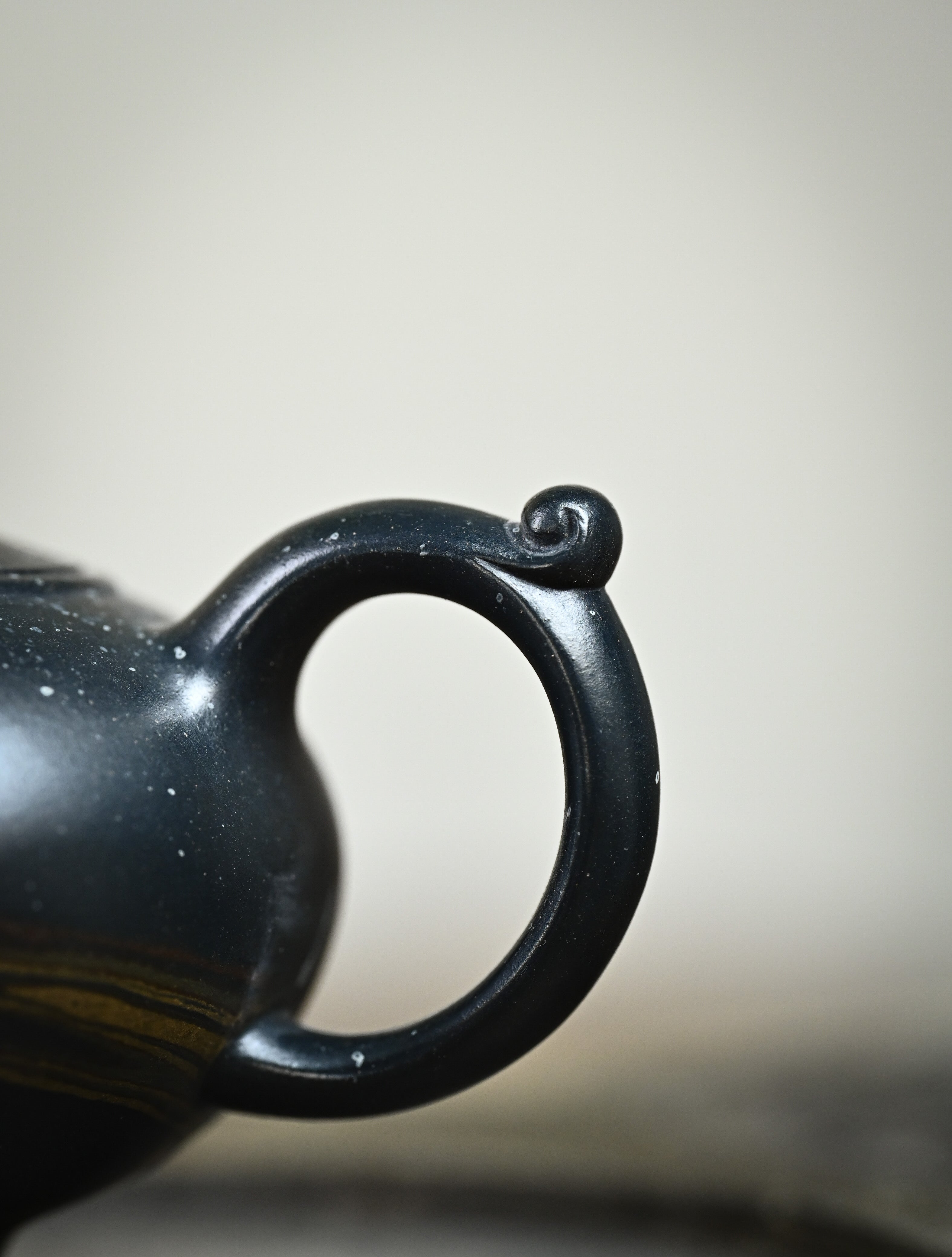 YANYOO handmade Yixing teapot featuring "Que Tou Qing" lvni clay and delicate Zisha clay blending technique, lifestyle detail handle.
