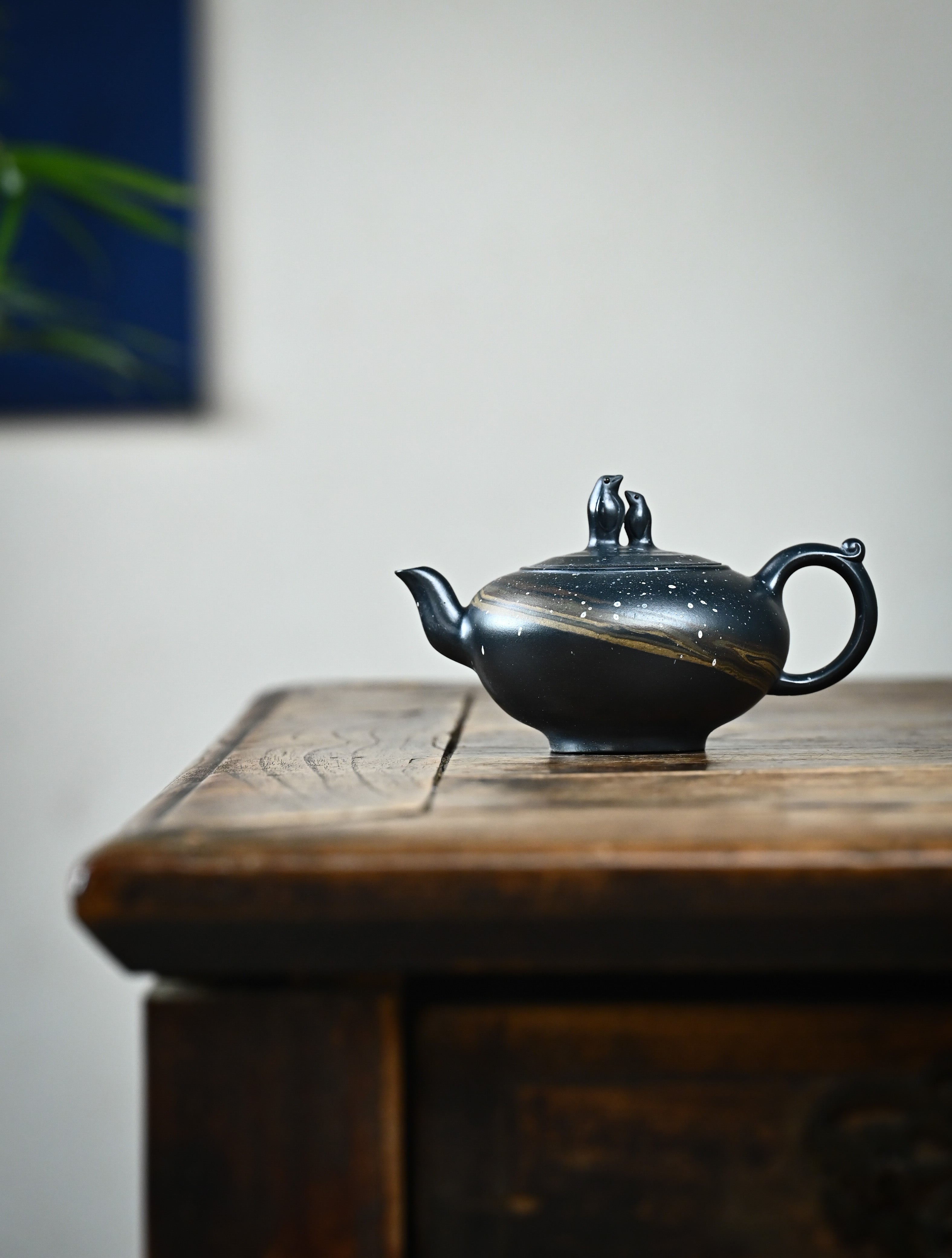 YANYOO handmade Yixing teapot featuring "Que Tou Qing" lvni clay and delicate Zisha clay blending technique, lifestyle wide-angle left side.