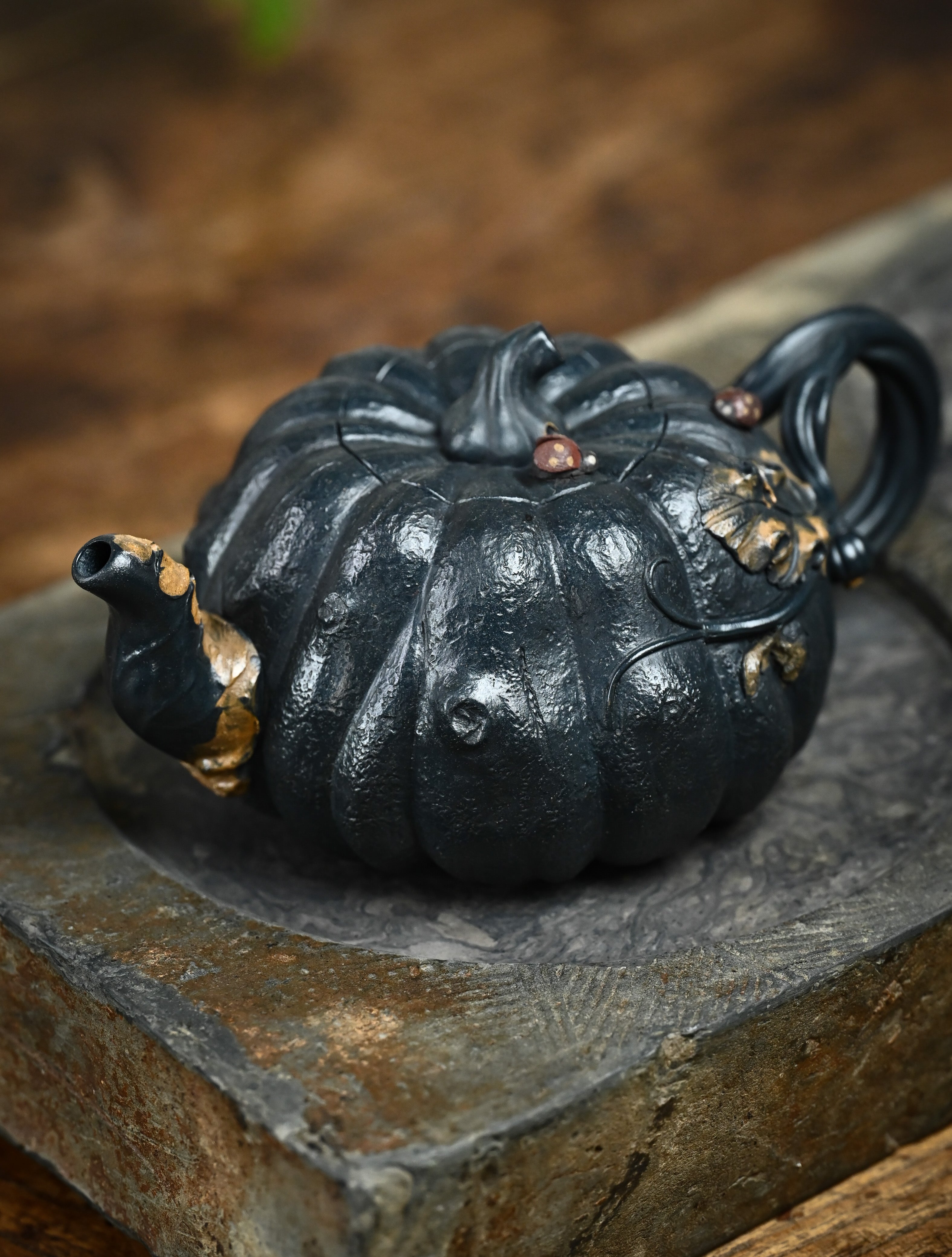 YANYOO handmade Yixing teapot featuring "Que Tou Qing" lvni clay and a lifelike pumpkin shape, lifestyle left side.