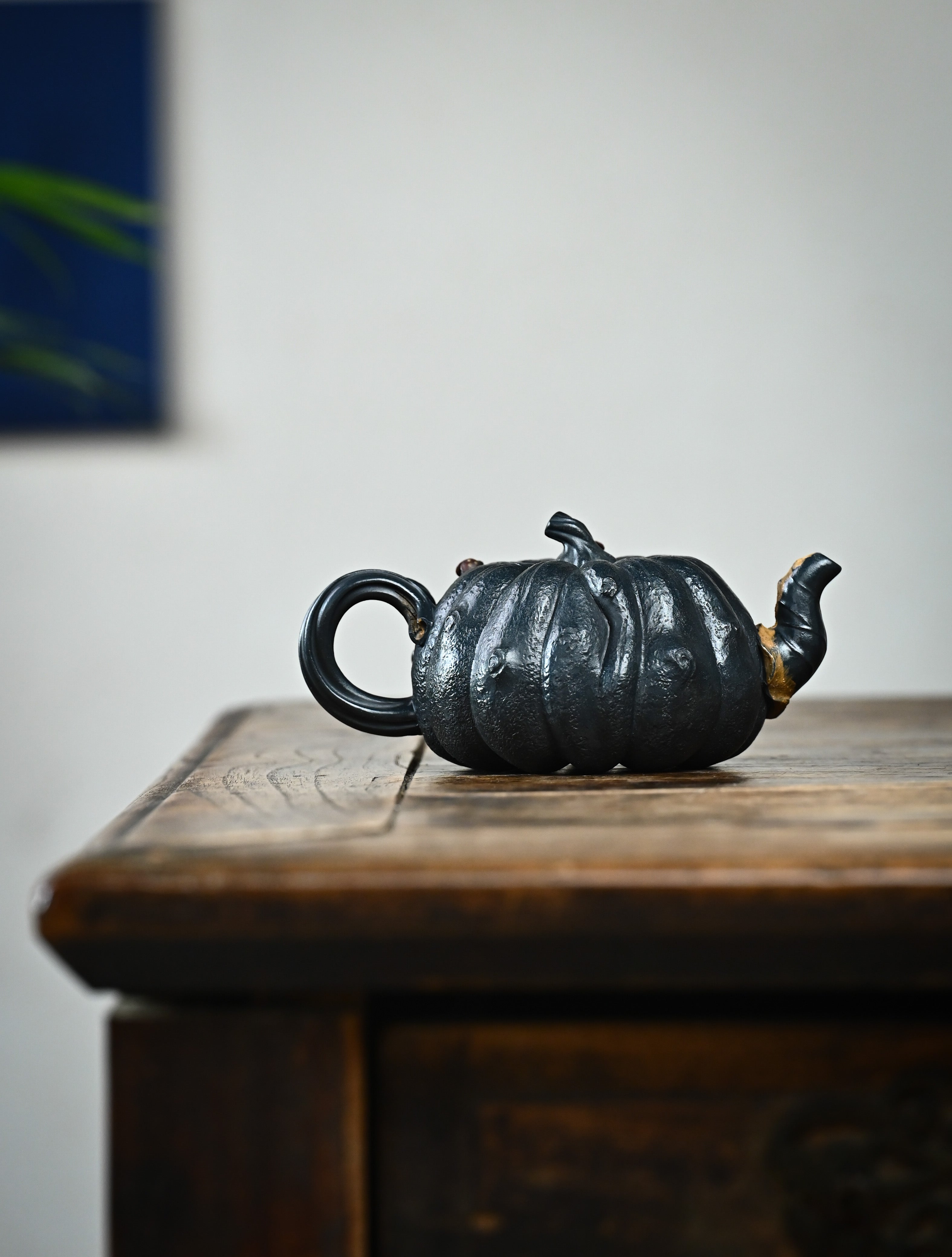 YANYOO handmade Yixing teapot featuring "Que Tou Qing" lvni clay and a lifelike pumpkin shape, lifestyle wide-angle right side.