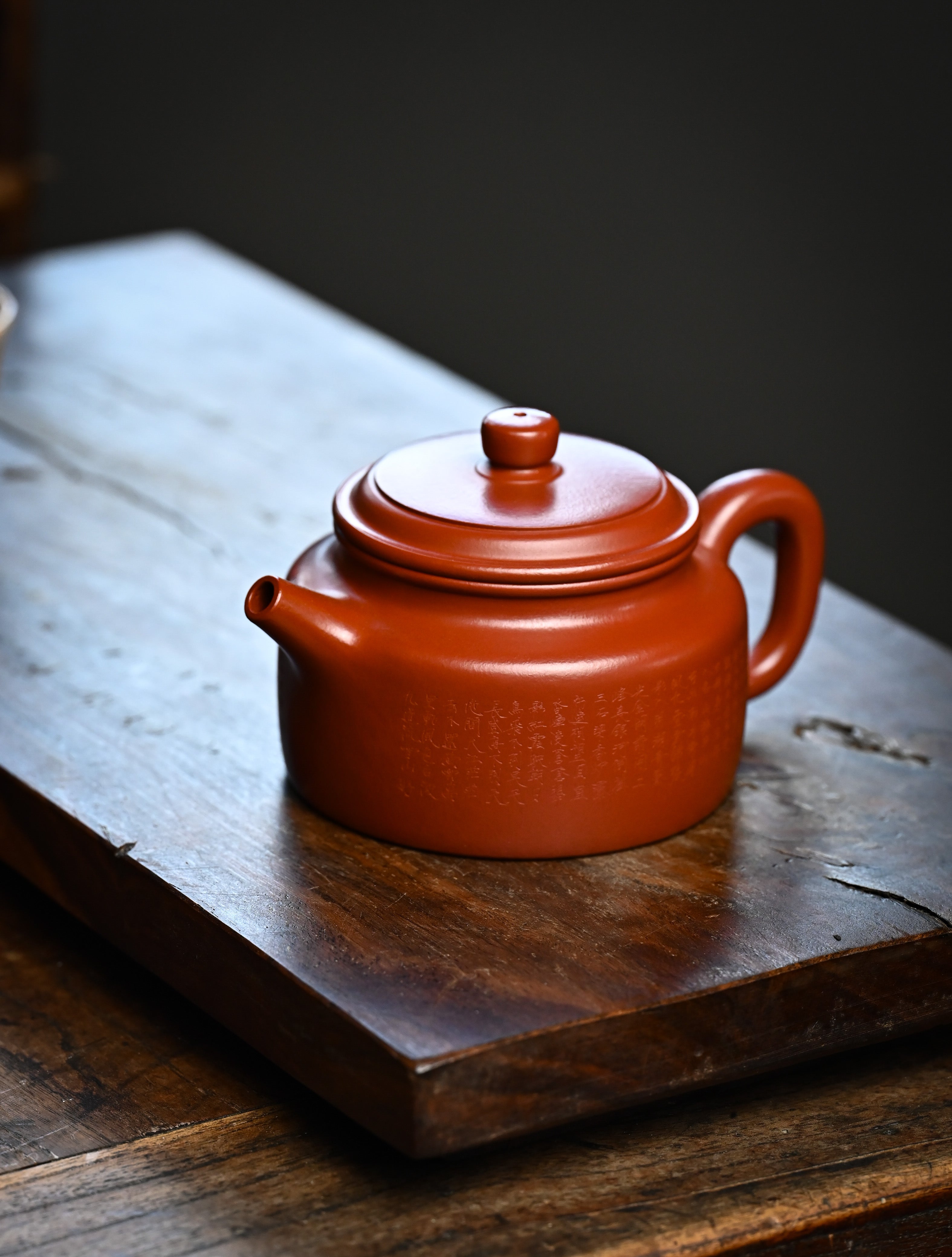 YANYOO handmade Yixing teapot featuring Zhuni clay and Chinese landscape engraving, lifestyle left side.