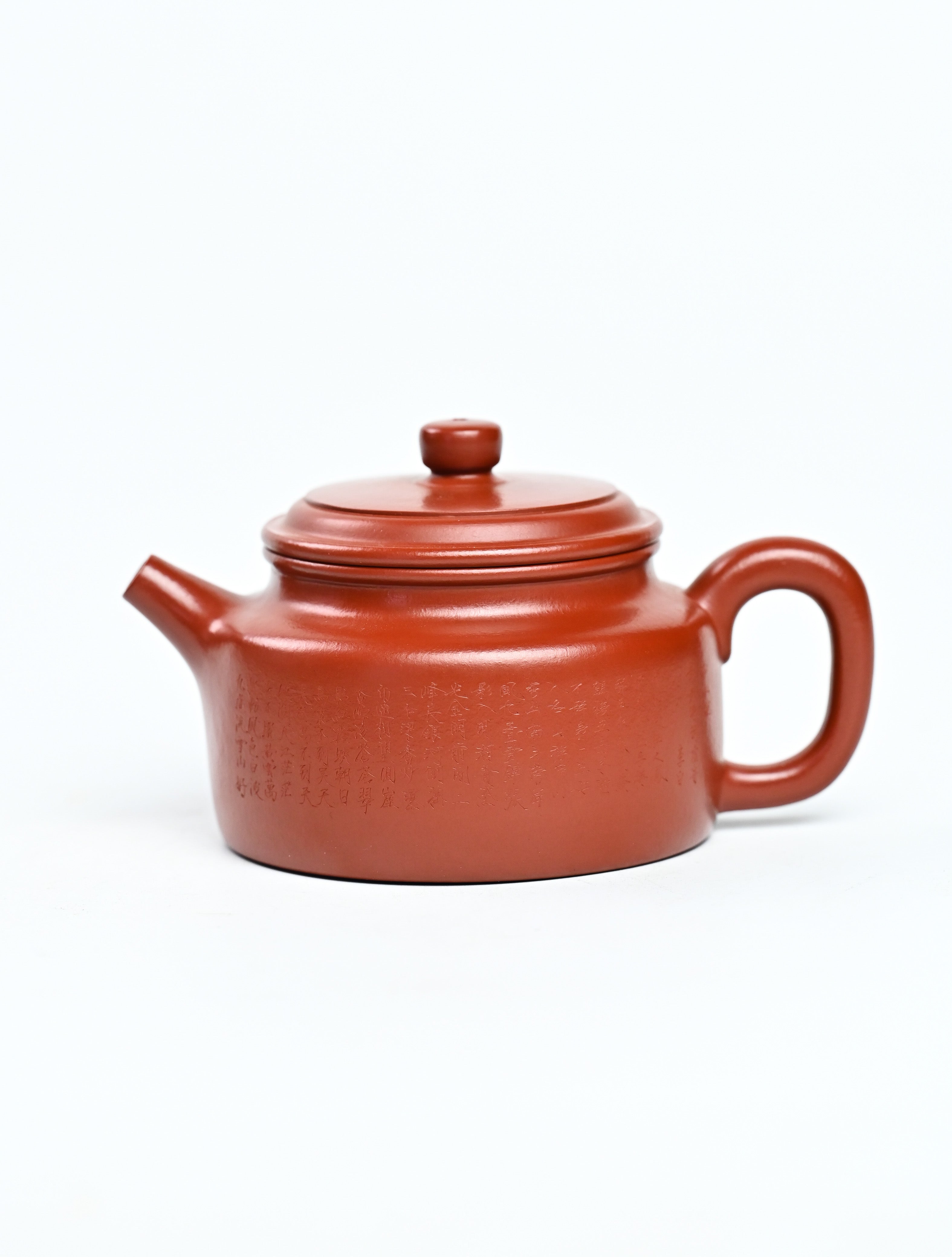 Handmade YANYOO Yixing teapot featuring Zhuni clay and Chinese landscape engraving, product left side.