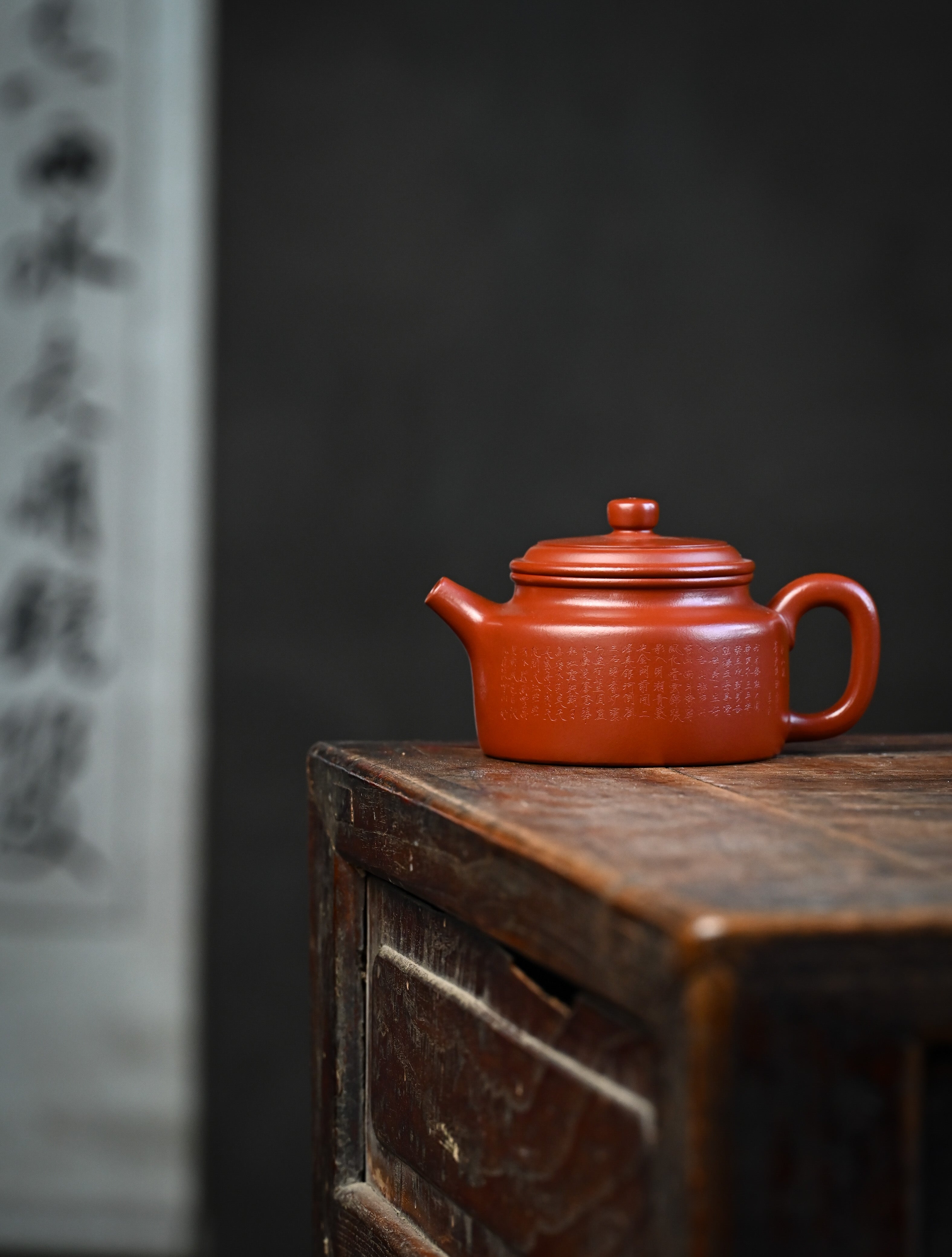 YANYOO handmade Yixing teapot featuring Zhuni clay and Chinese landscape engraving, lifestyle wide-angle left side.