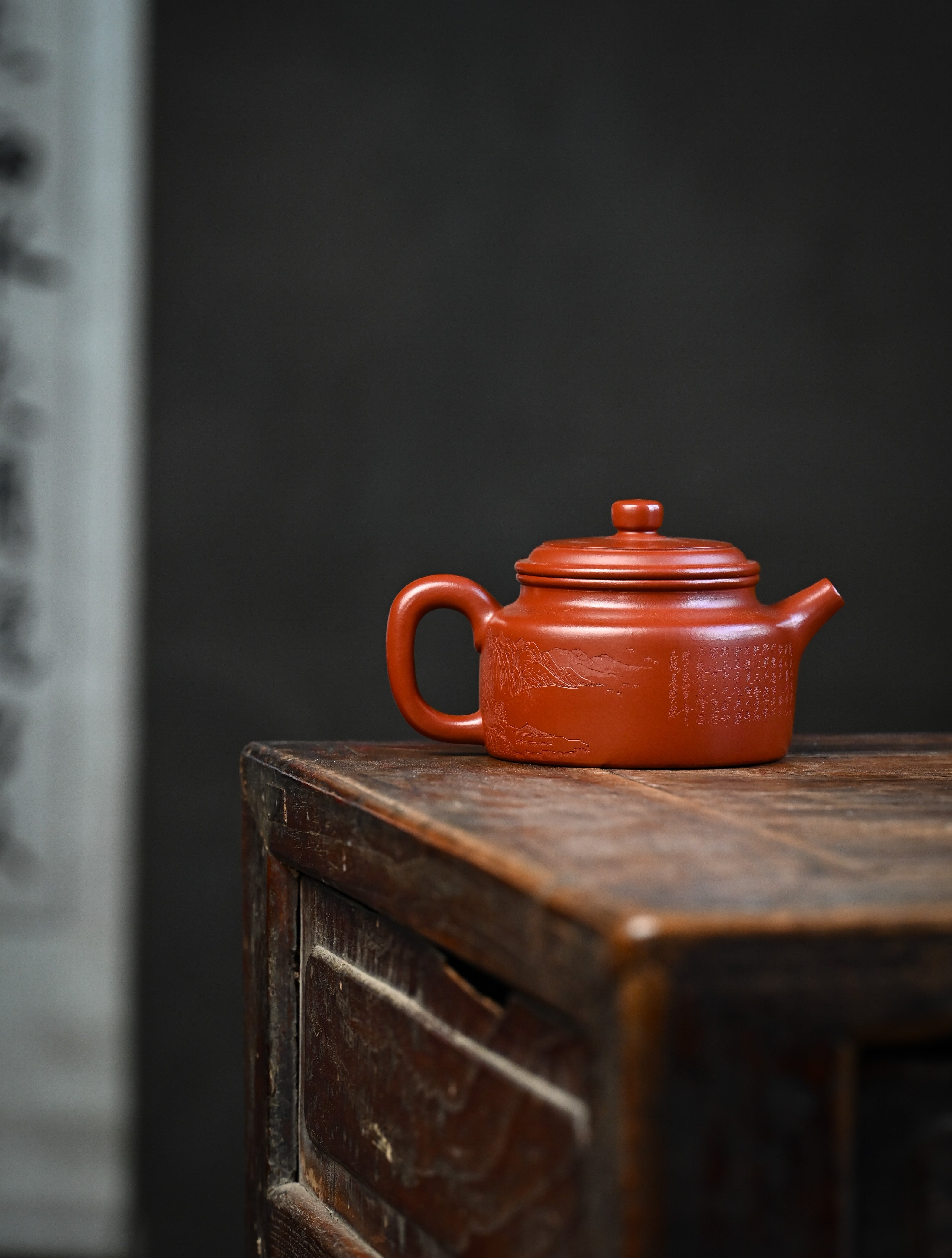 YANYOO handmade Yixing teapot featuring Zhuni clay and Chinese landscape engraving, lifestyle wide-angle right side.