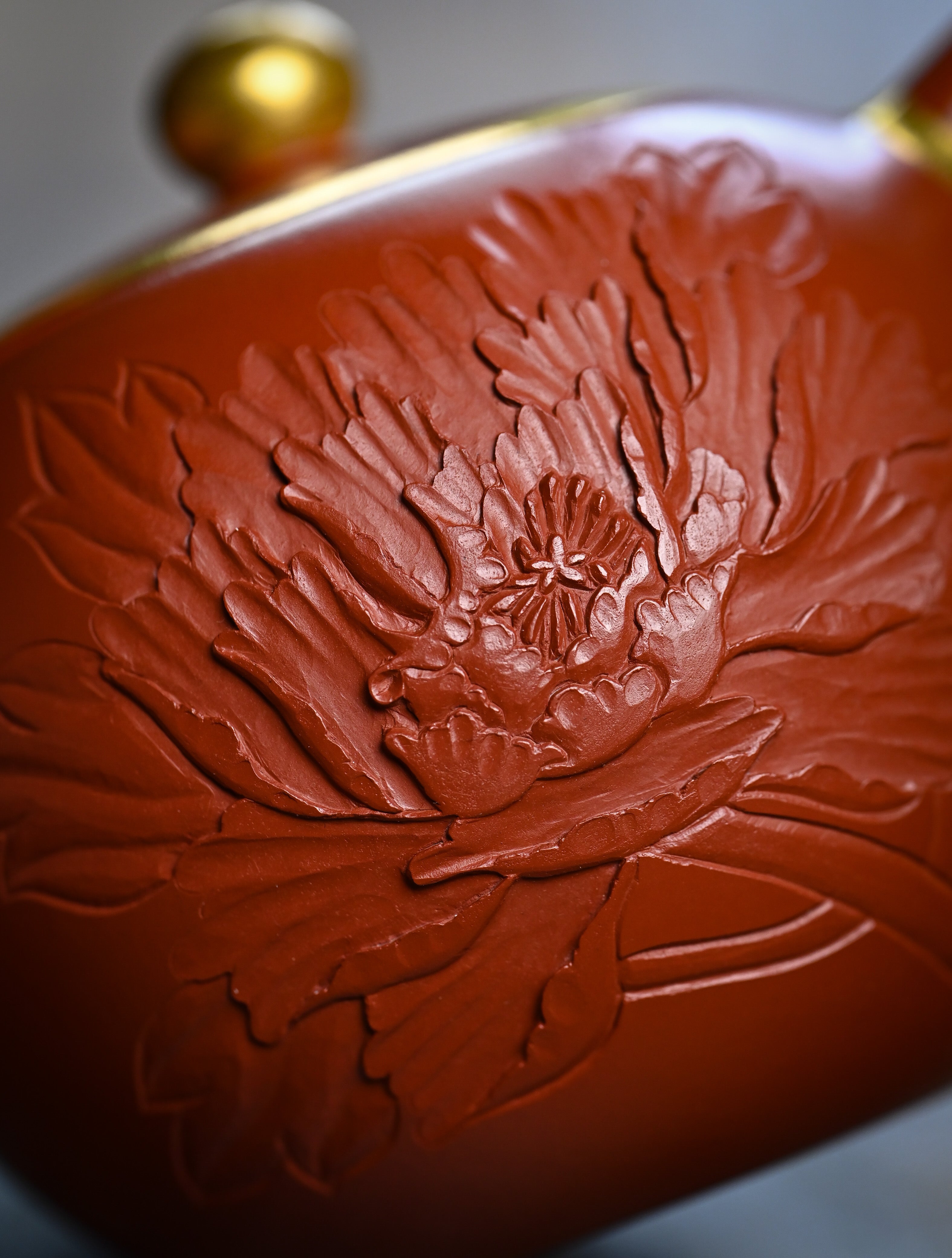 YANYOO handmade Yixing teapot featuring premium Zhuni clay and relief engravings, lifestyle detail front.