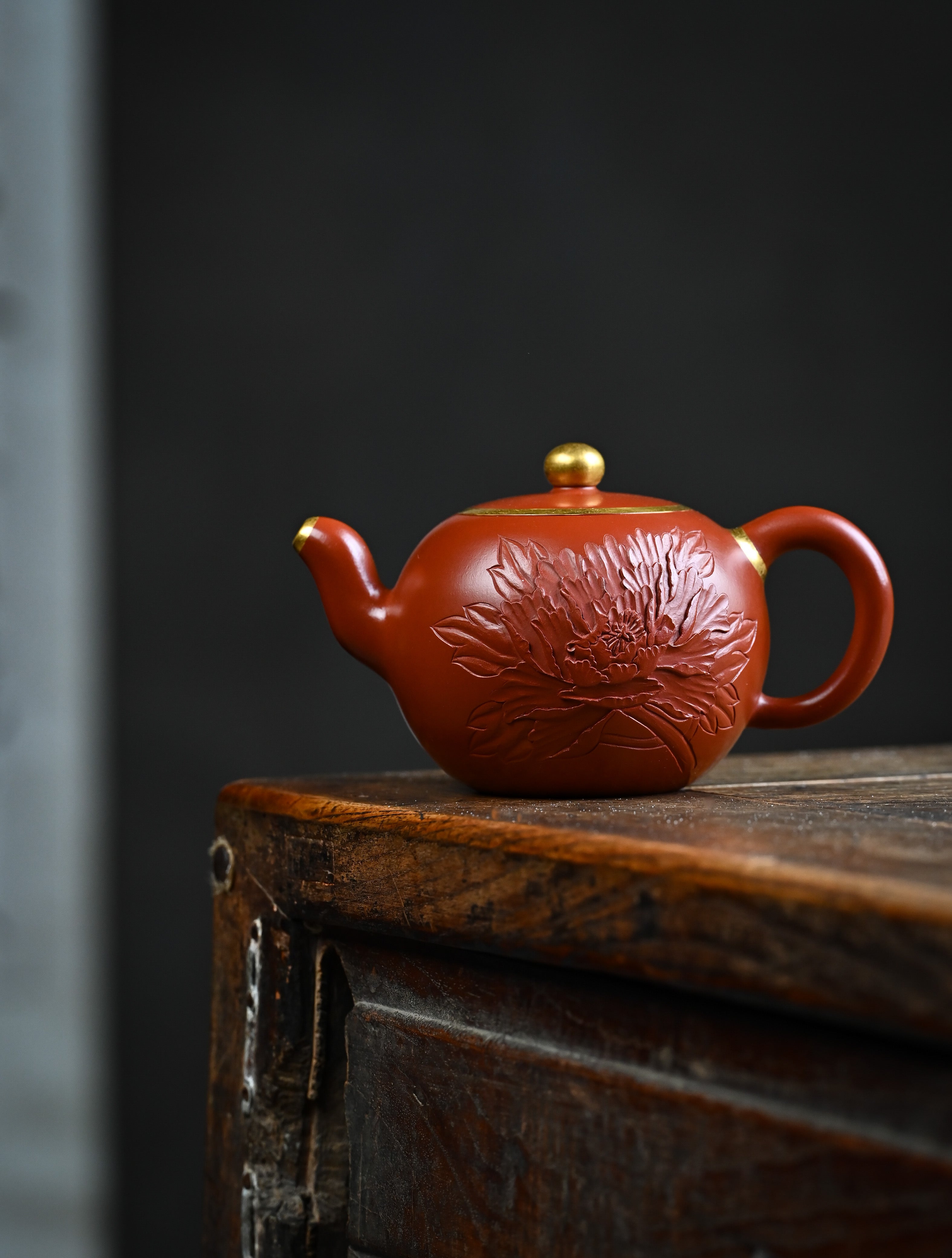 YANYOO handmade Yixing teapot featuring premium Zhuni clay and relief engravings, lifestyle wide-angle left side.