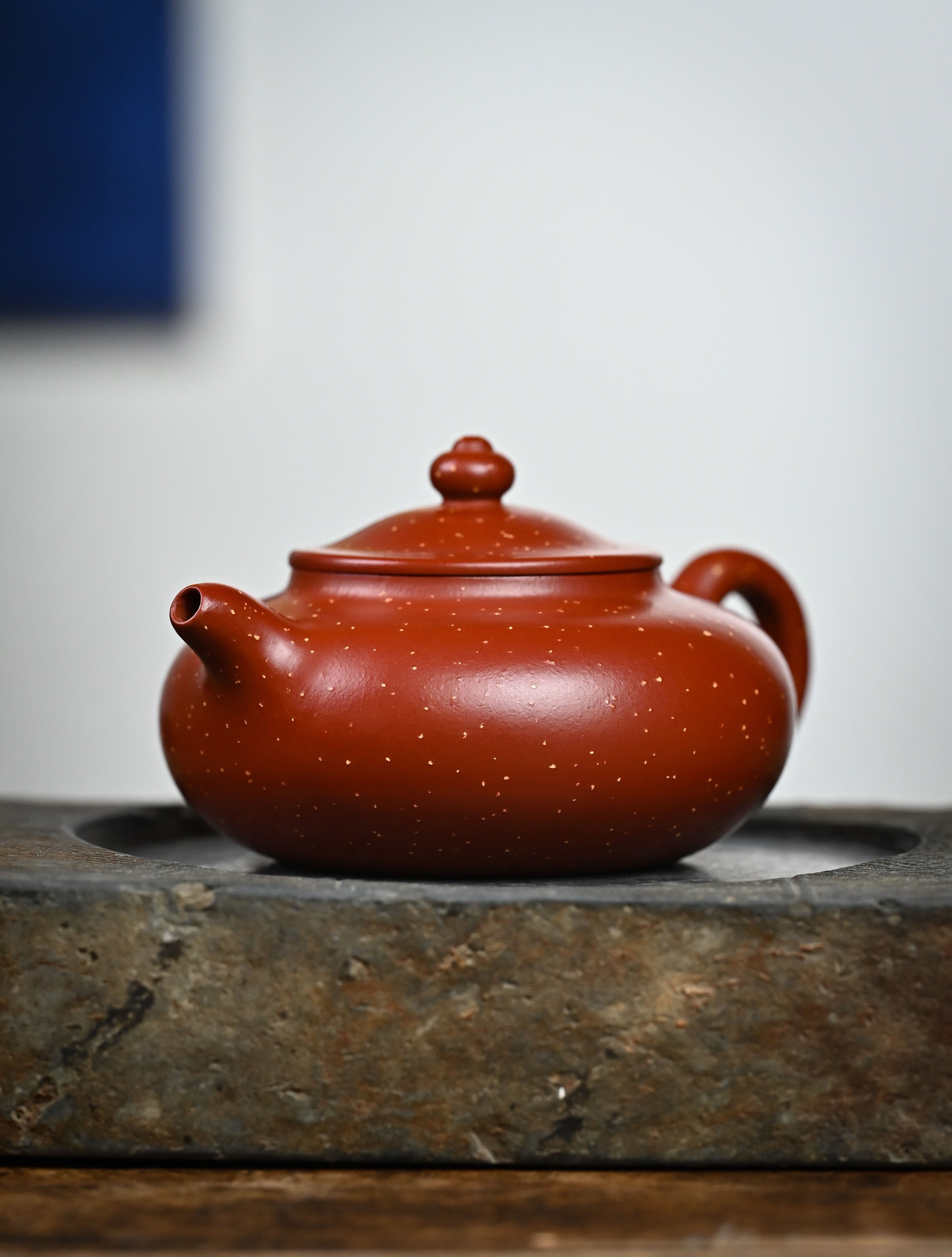 YANYOO handmade Yixing teapot featuring Zhuni Da Hong Pao clay and sand paving technique, lifestyle front side.