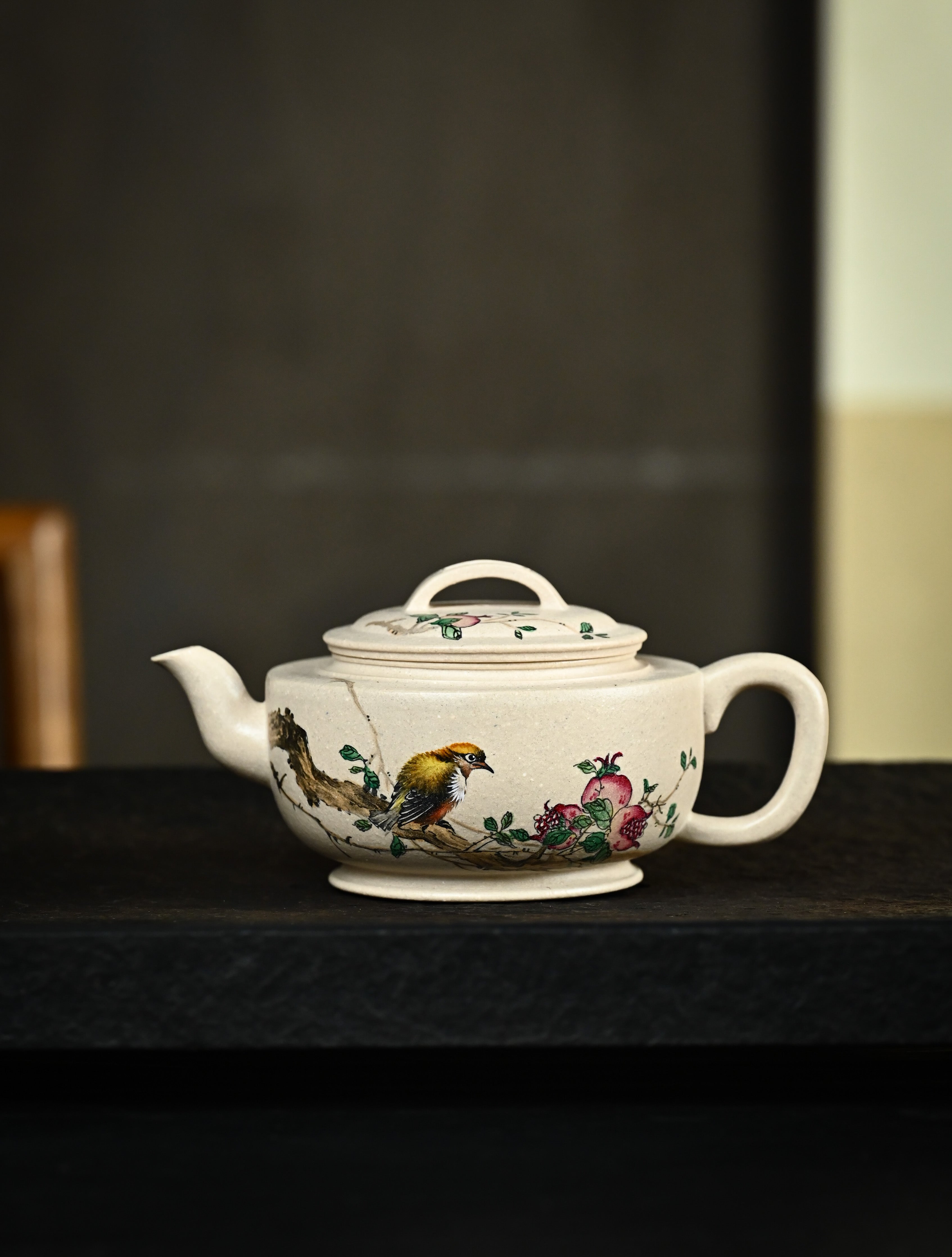 YANYOO handmade Yixing teapot featuring suet white jade Duanni clay and delicate bird-and-pomegranate themed clay painting, Gong Deng, lifestyle wide-angle left side.