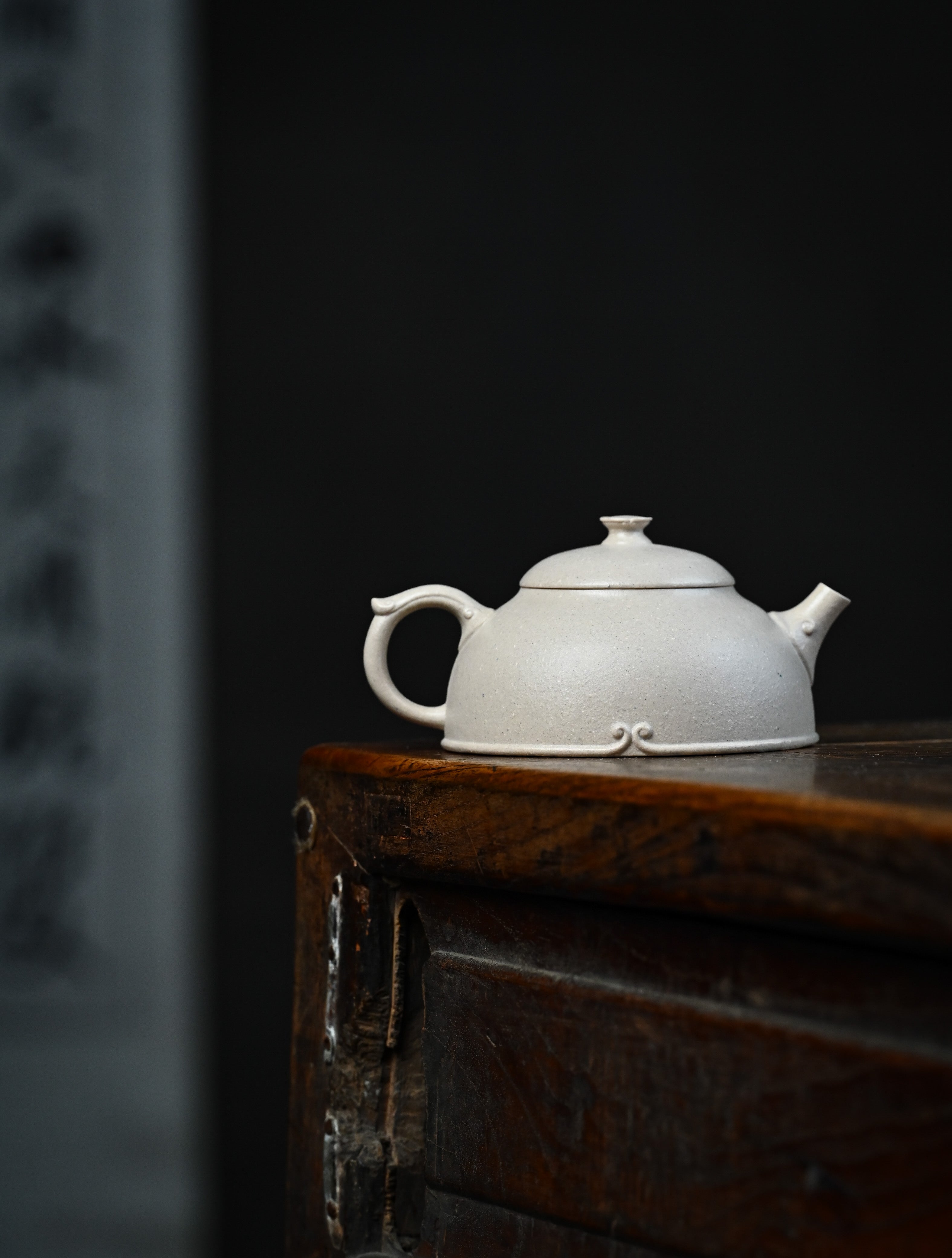 YANYOO handmade Yixing teapot featuring suet white jade Duanni clay and delicate bird-and-peach themed clay painting, lifestyle wide-angle right side.