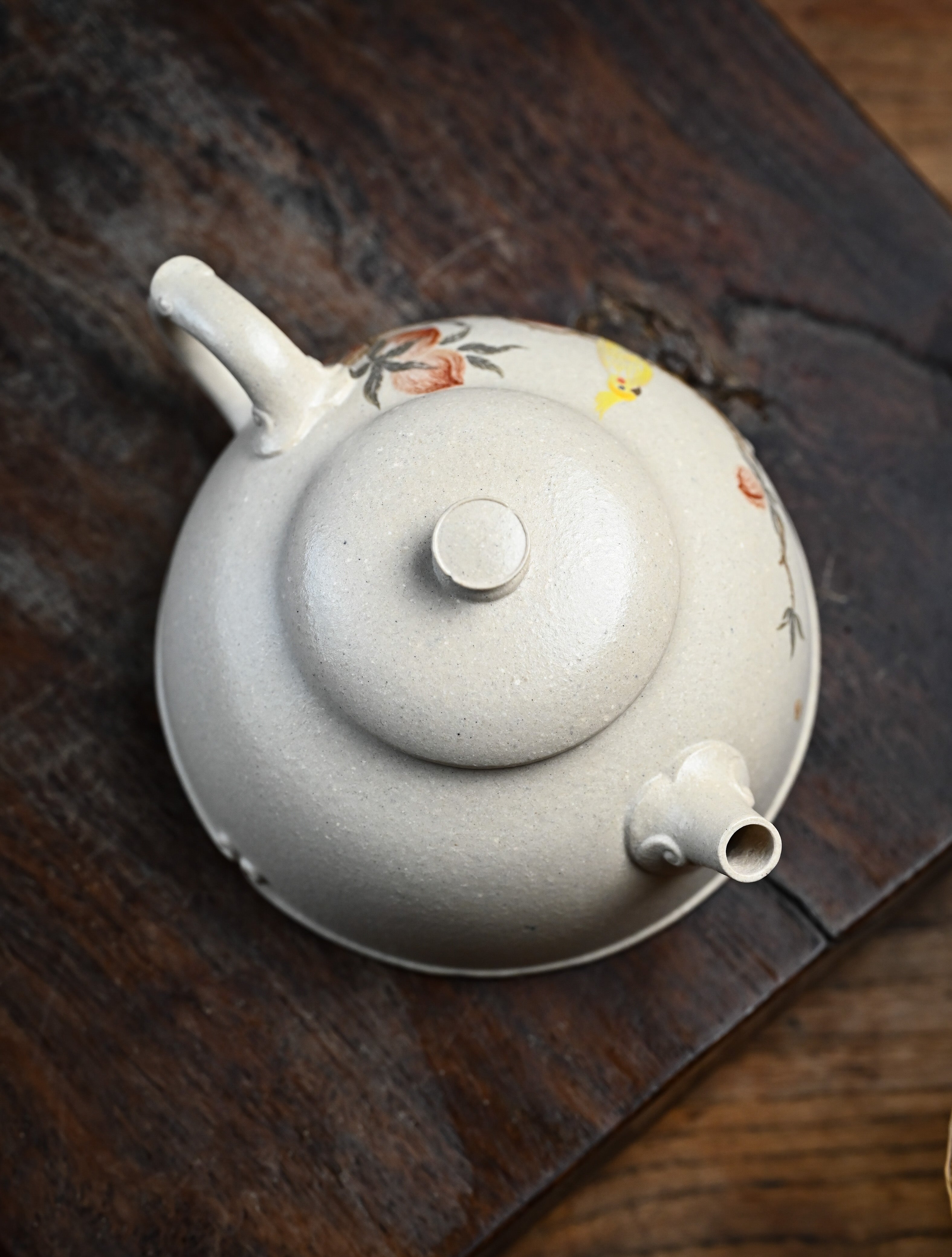 YANYOO handmade Yixing teapot featuring suet white jade Duanni clay and delicate bird-and-peach themed clay painting, lifestyle top side.