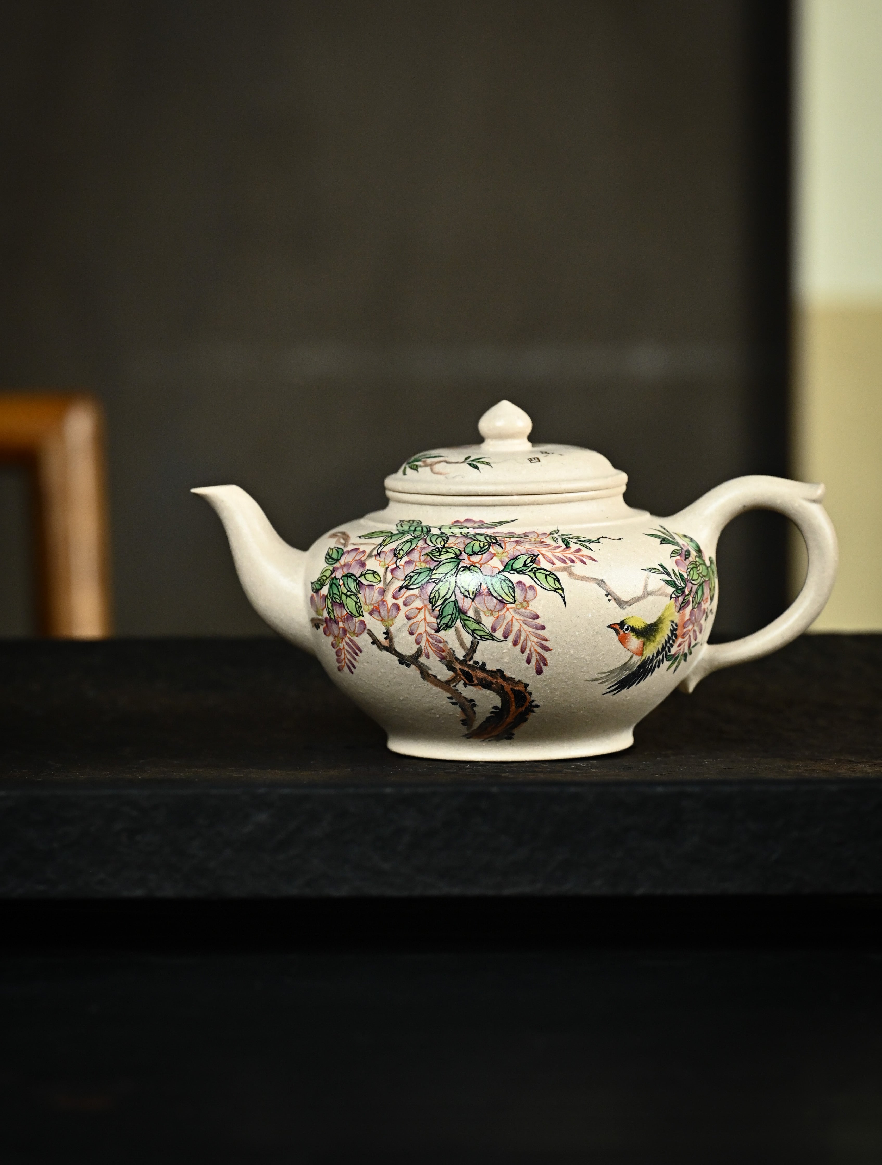 YANYOO handmade Yixing teapot featuring suet white jade Duanni clay and delicate bird-and-peach themed clay painting, Xiao Ying, lifestyle wide-angle left side.