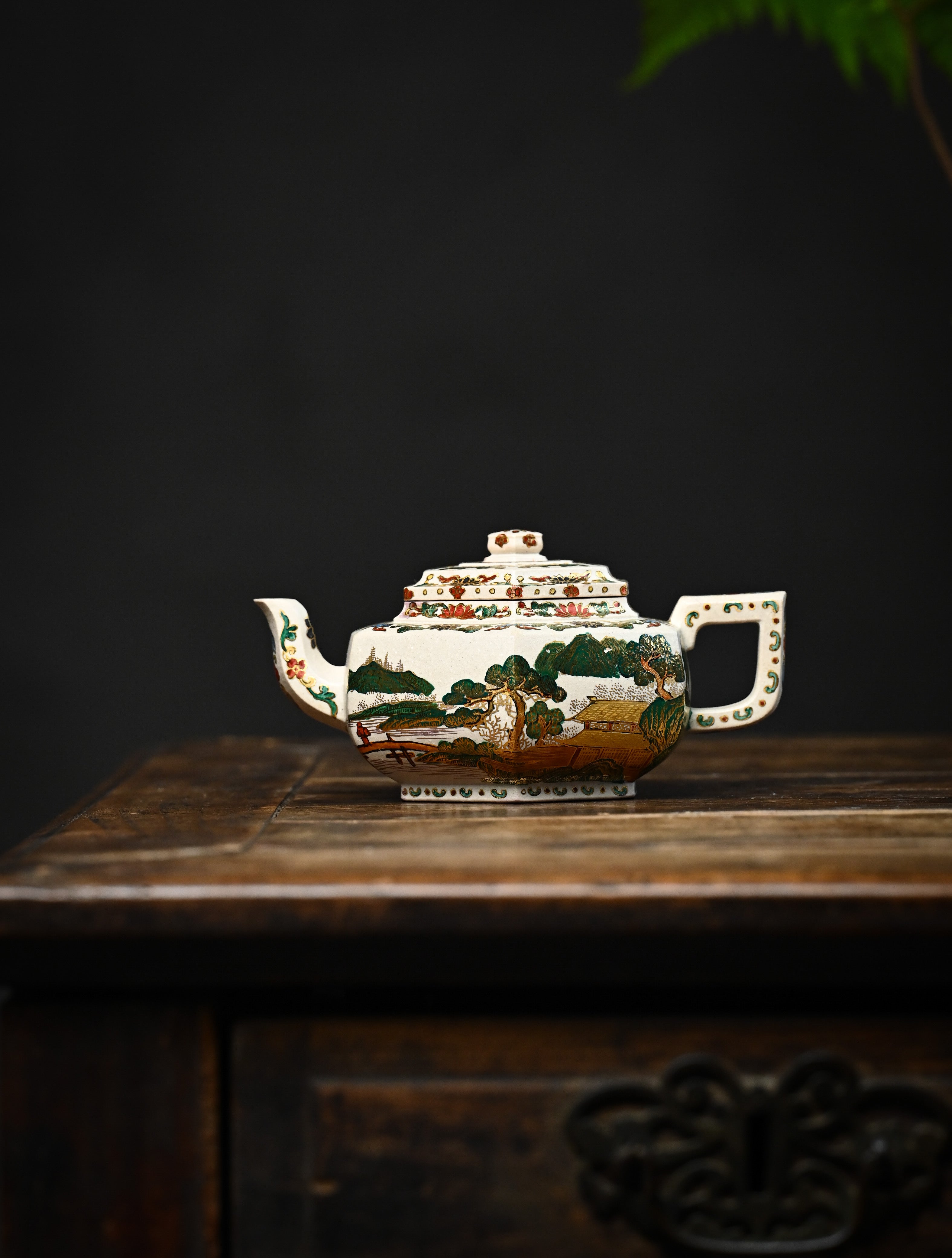 YANYOO handmade Yixing teapot featuring suet white jade Duanni clay and delicate Falangcai, lifestyle wide-angle left side.