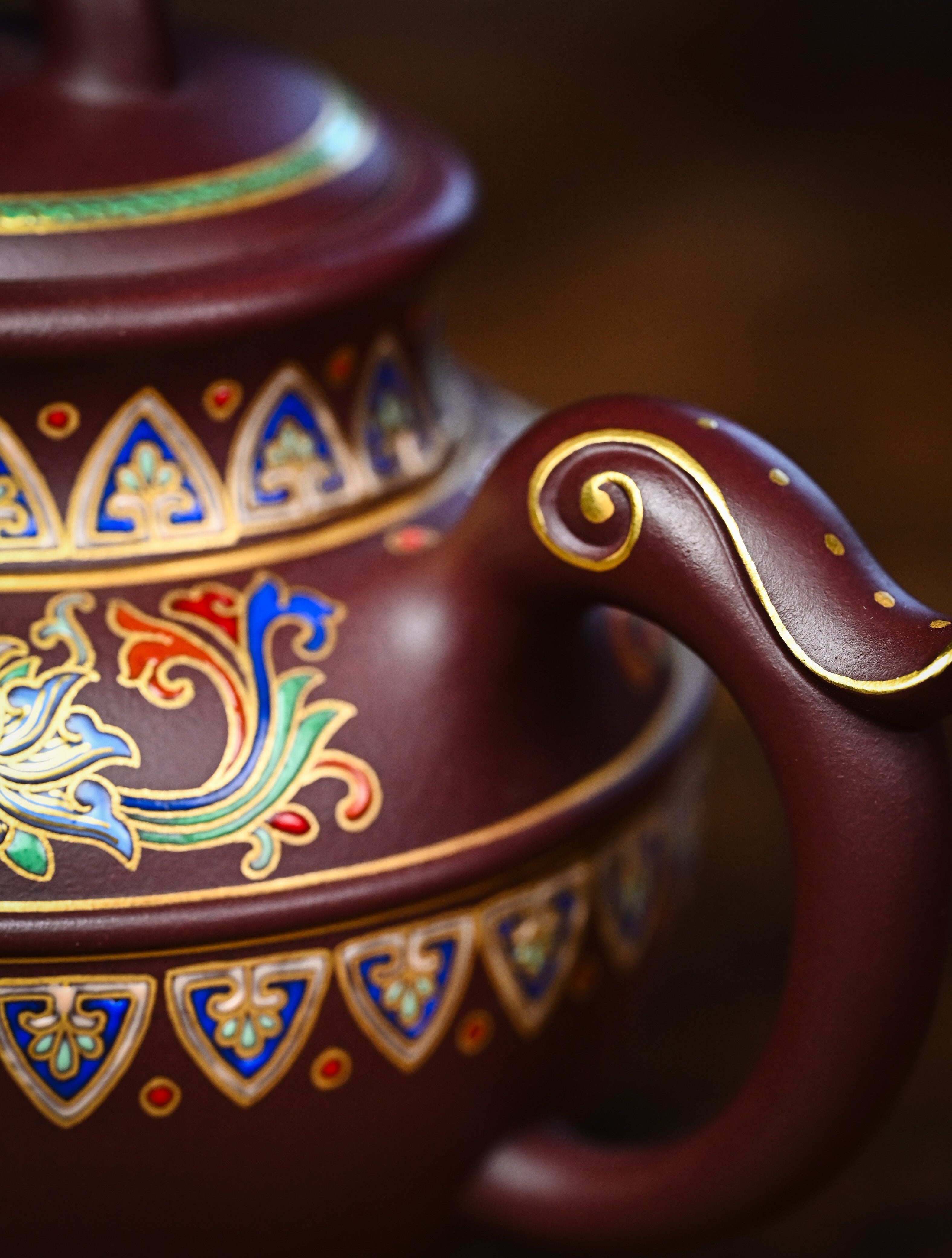 YANYOO handmade Yixing teapot featuring purple clay and lotus-themed Falangcai mimicing a phoenix, lifestyle detail handle.