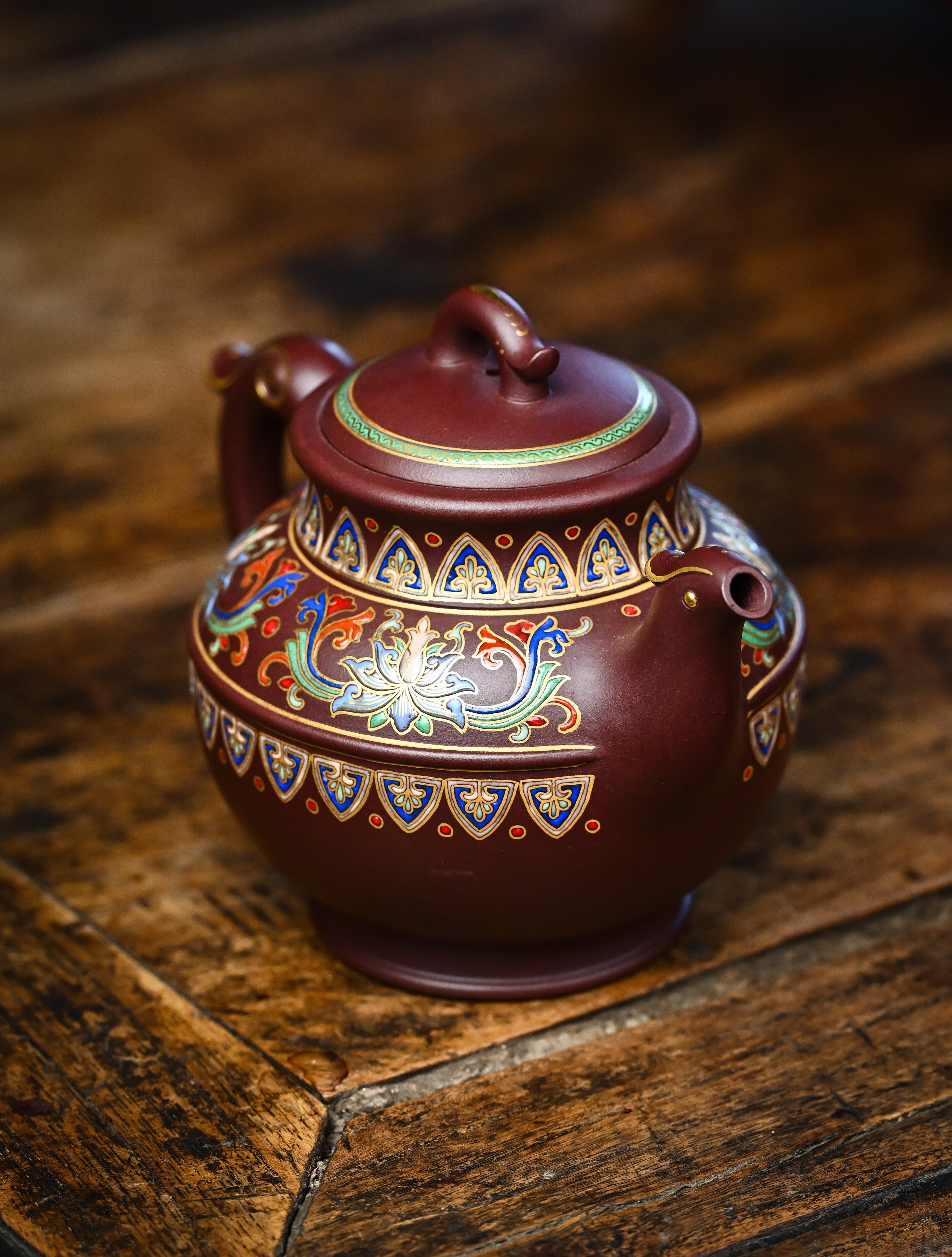 YANYOO handmade Yixing teapot featuring purple clay and lotus-themed Falangcai mimicing a phoenix, lifestyle right side.