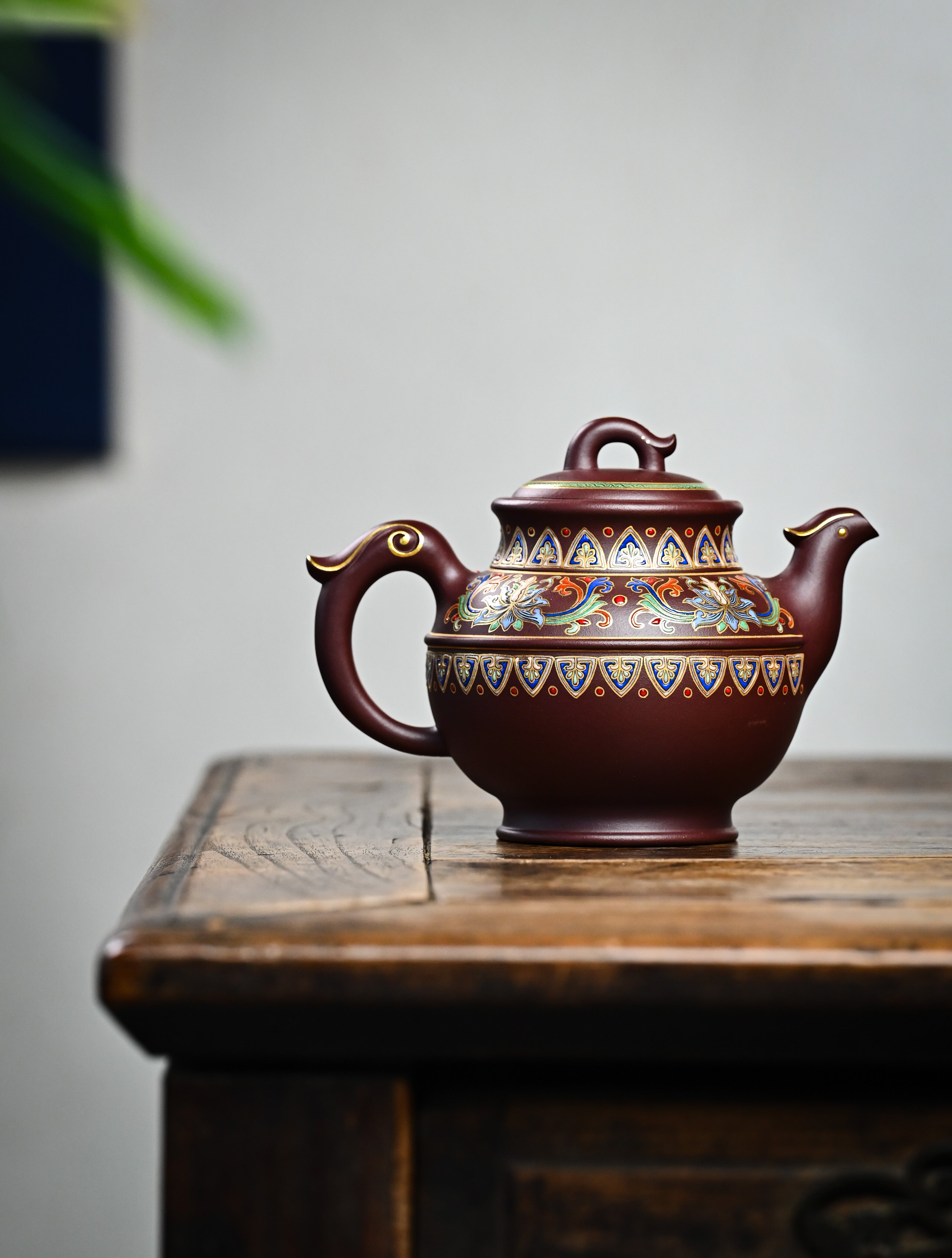 YANYOO handmade Yixing teapot featuring purple clay and lotus-themed Falangcai mimicing a phoenix, lifestyle wide-angle right side.