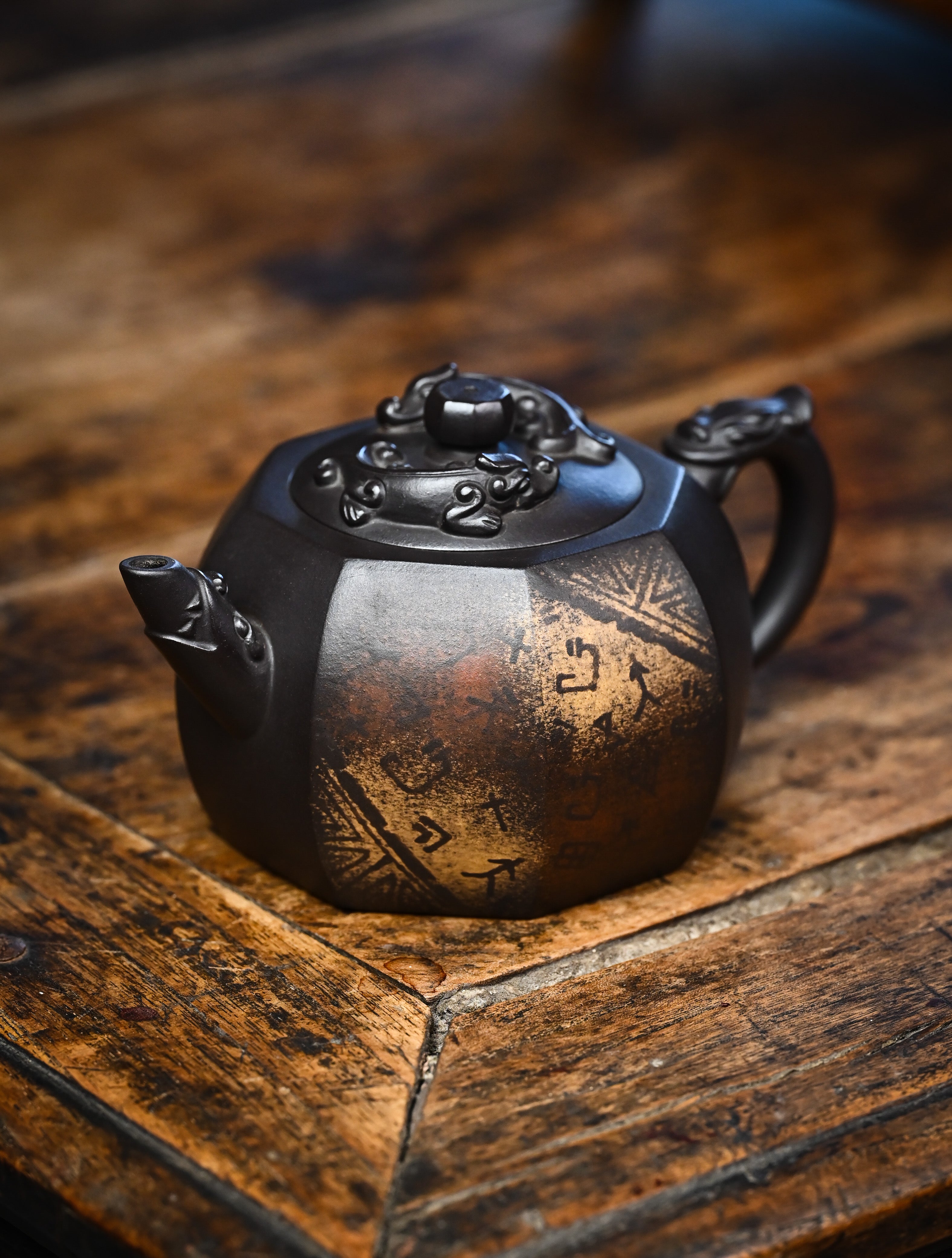 YANYOO handmade Yixing teapot featuring aged Celadon clay, Oracle Bone scripts pattern and the pioneering color decoration method, lifestyle left side.