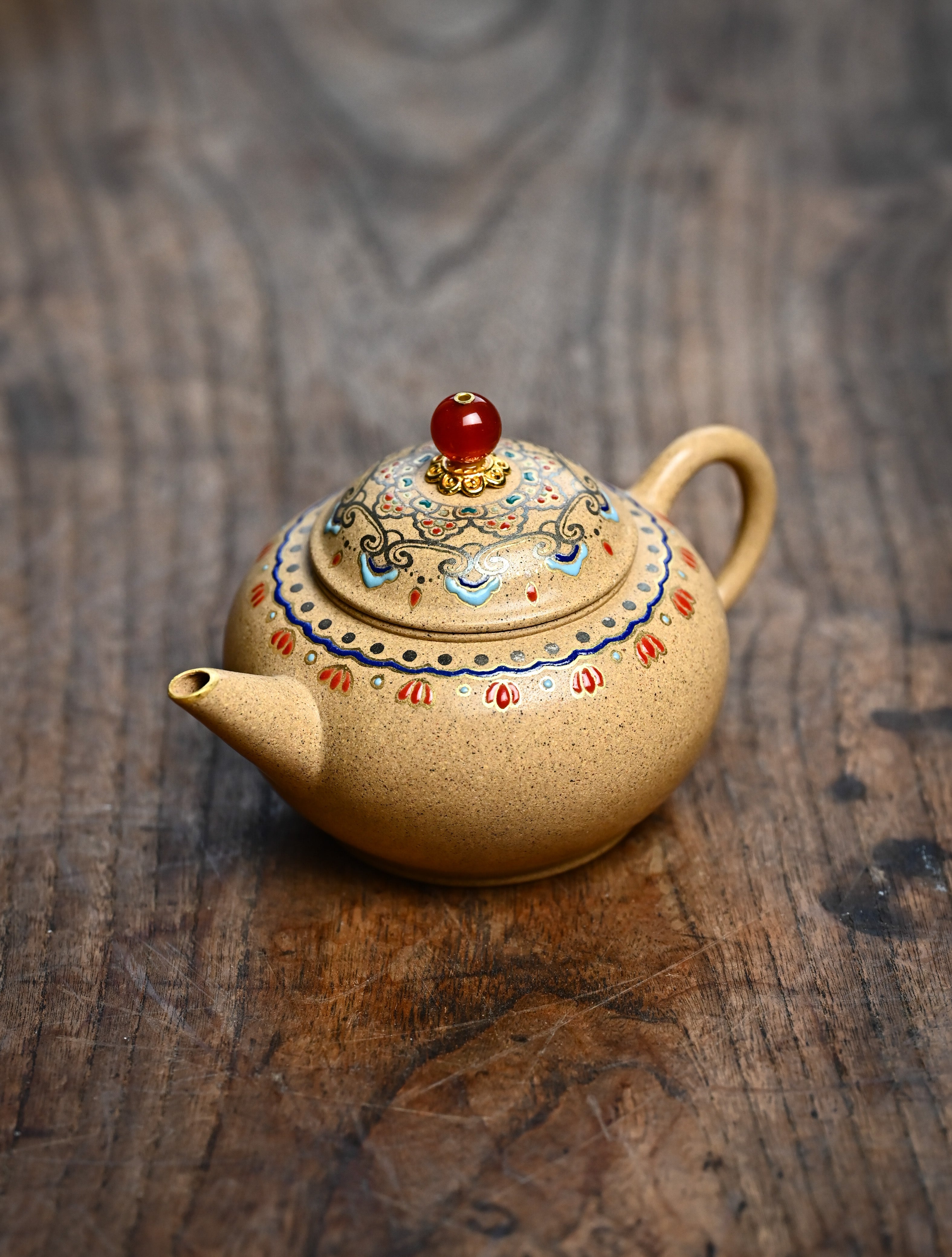 YANYOO handmade Yixing teapot featuring Duanni clay, Shuimo polish technique and delicate Falangcai, lifestyle left side.