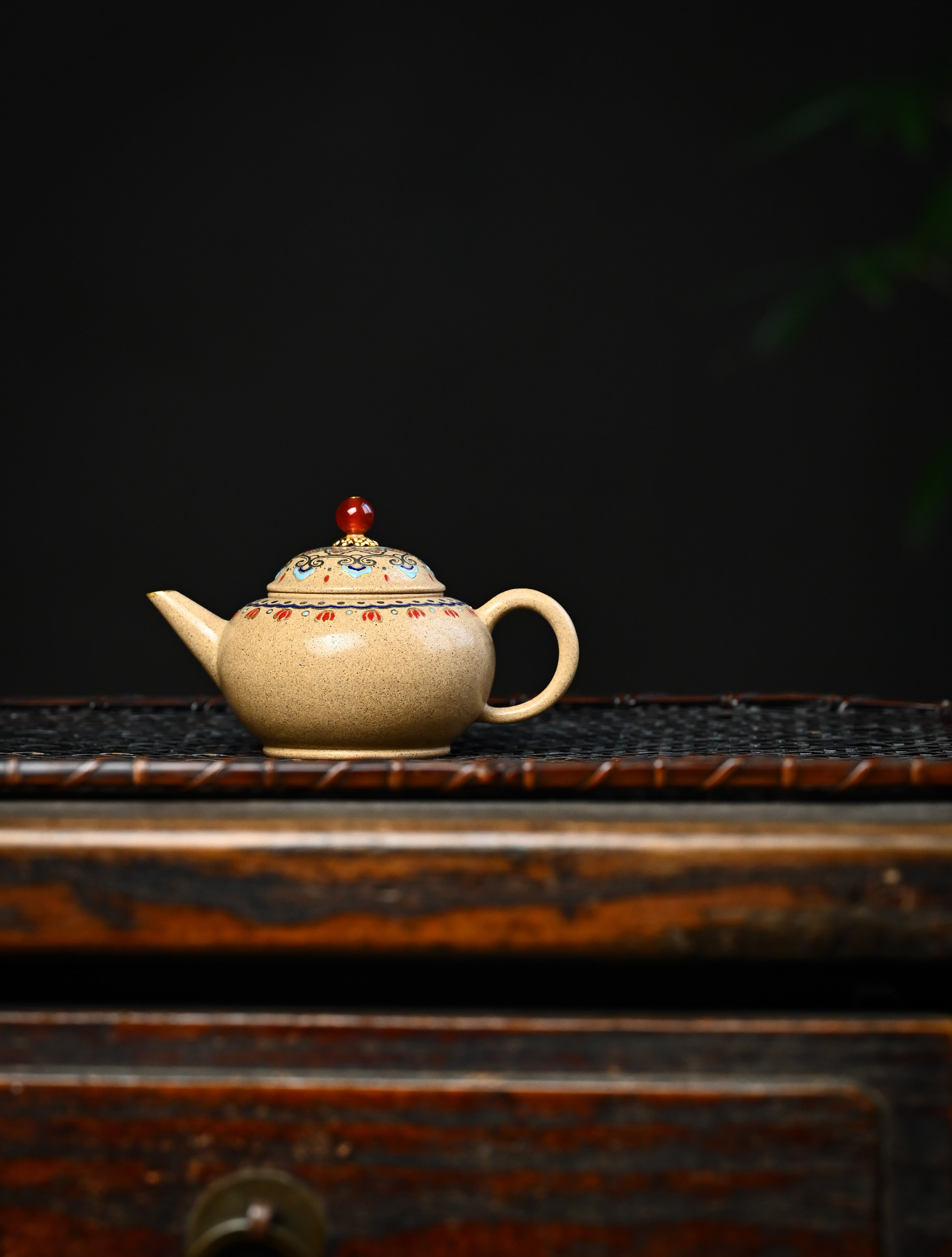 YANYOO handmade Yixing teapot featuring Duanni clay, Shuimo polish technique and delicate Falangcai, lifestyle wide-angle left side.