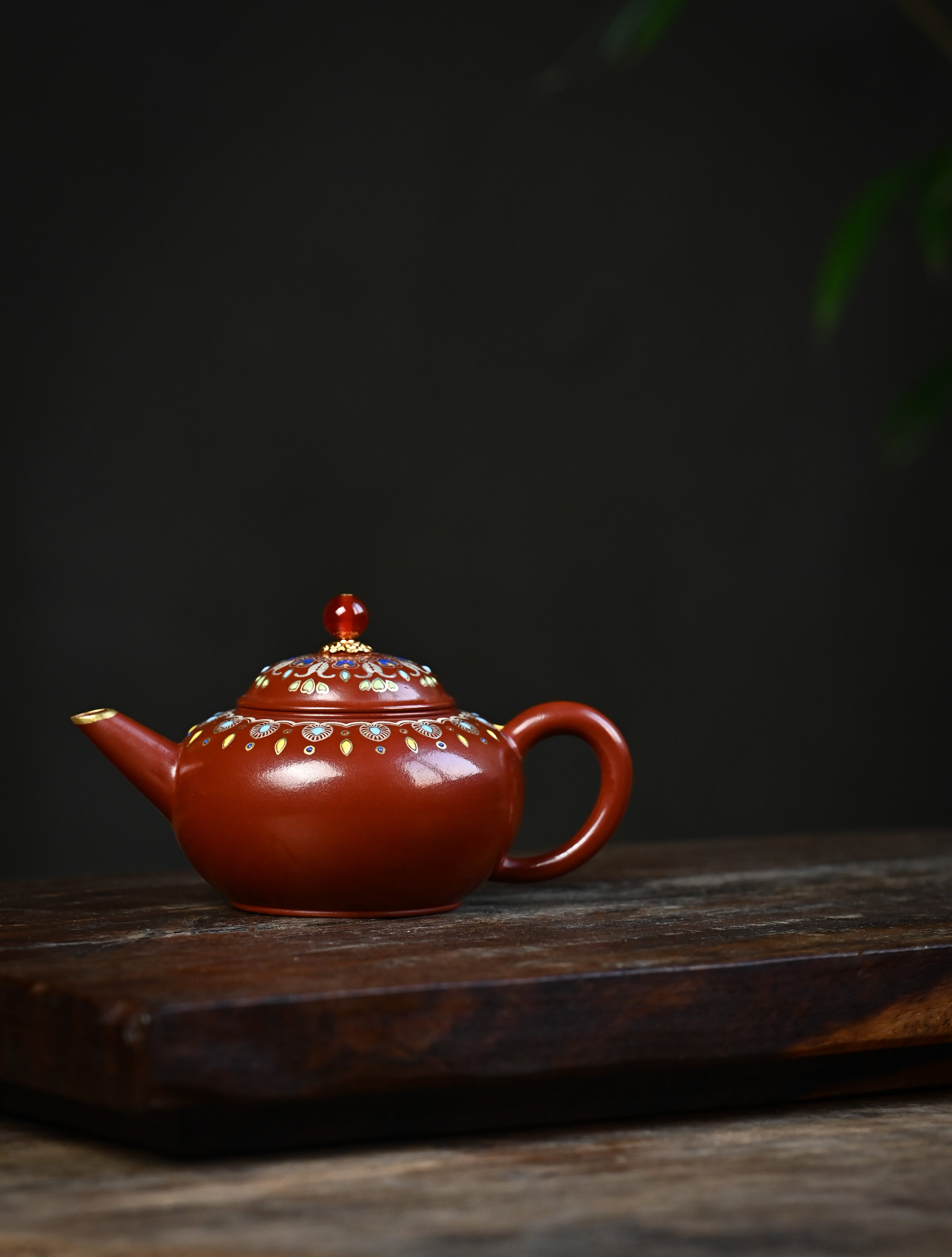 YANYOO handmade Yixing teapot featuring Zhuni clay, water polish technique (Shuimo) and delicate Falangcai, lifestyle wide-angle left side.