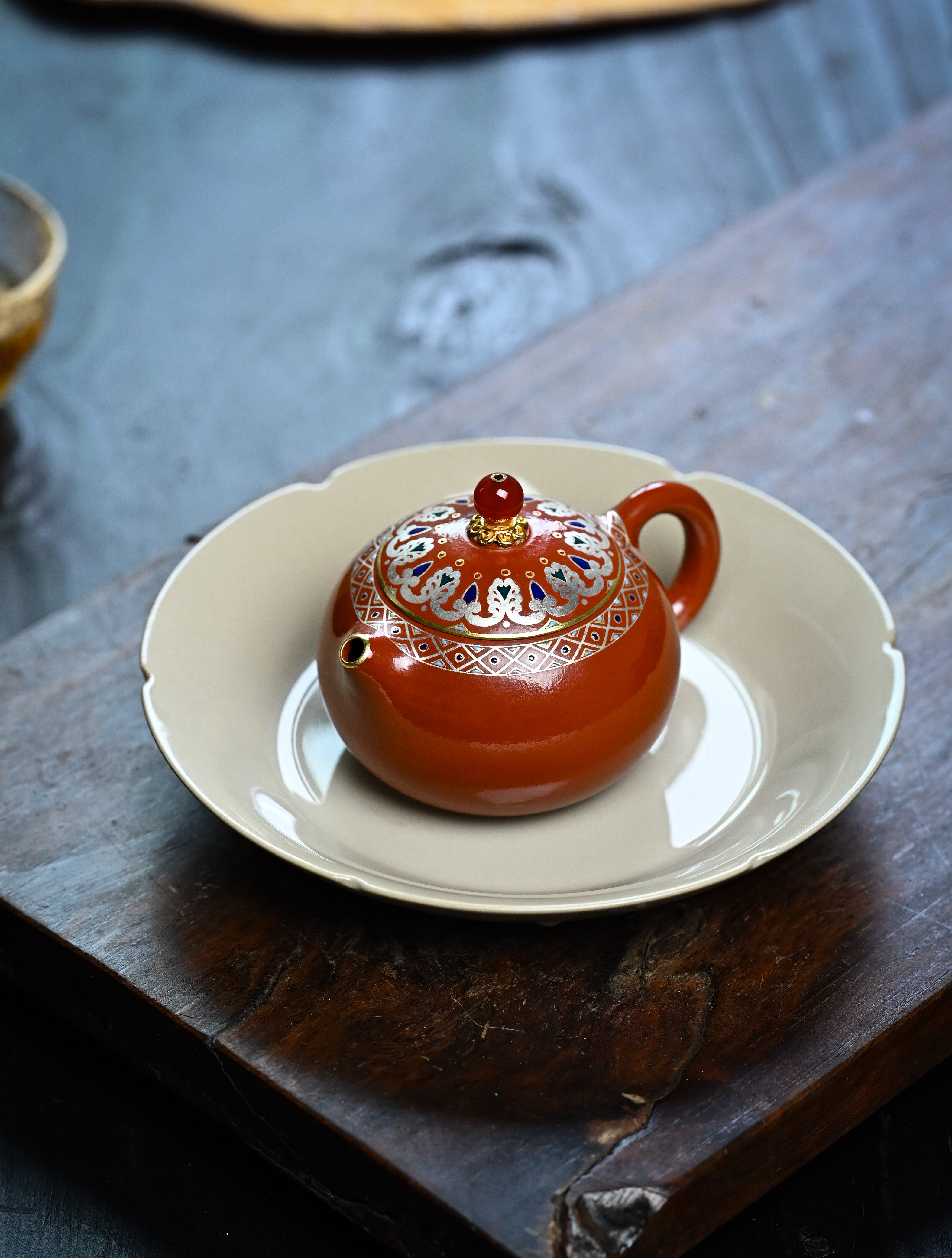 YANYOO handmade Yixing teapot featuring Shuimo polish technique and delicate Falangcai, lifestyle left side.