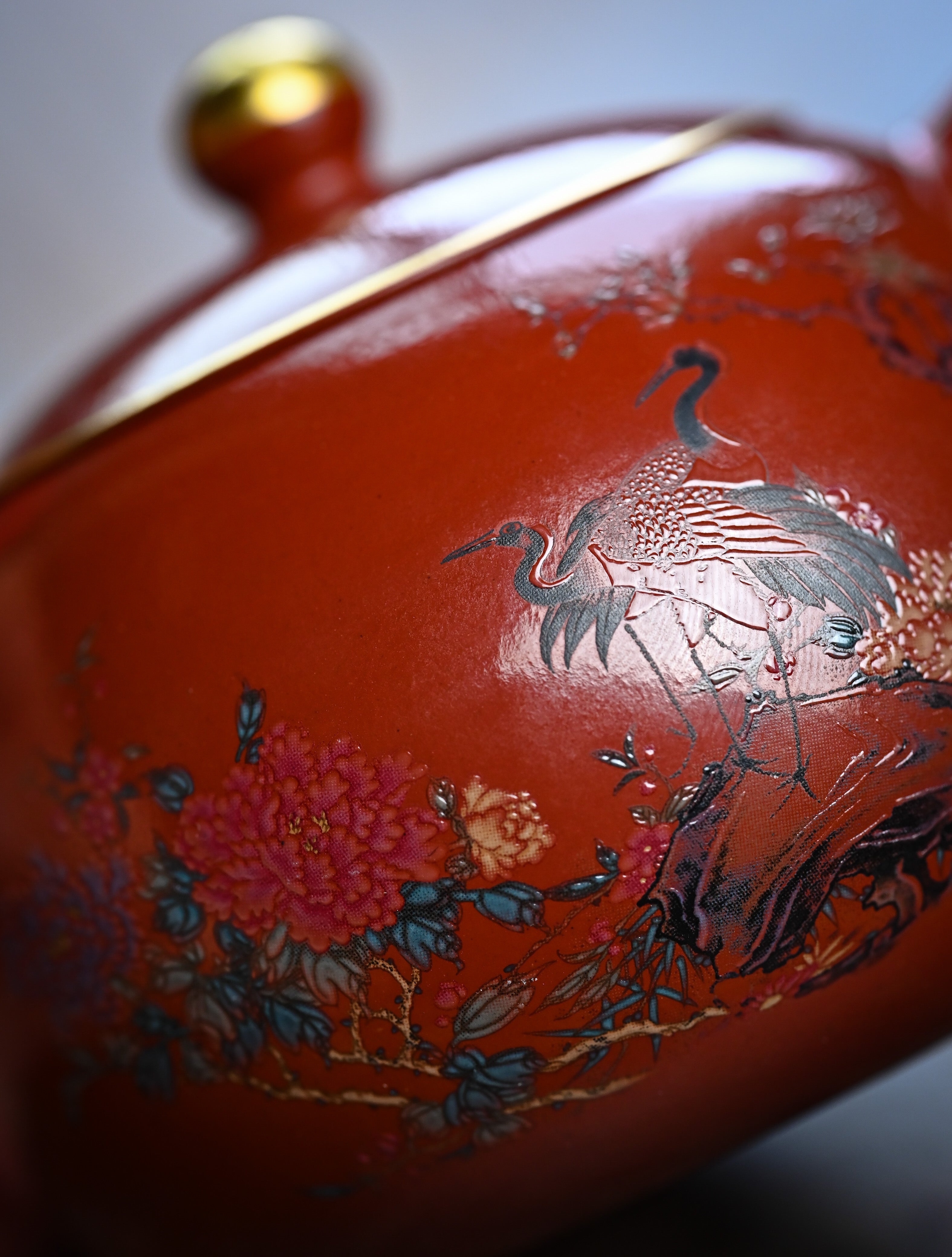 YANYOO handmade Yixing teapot featuring Shuimo polish technique and delicate painting of crane-and-flower motif, lifestyle detail.