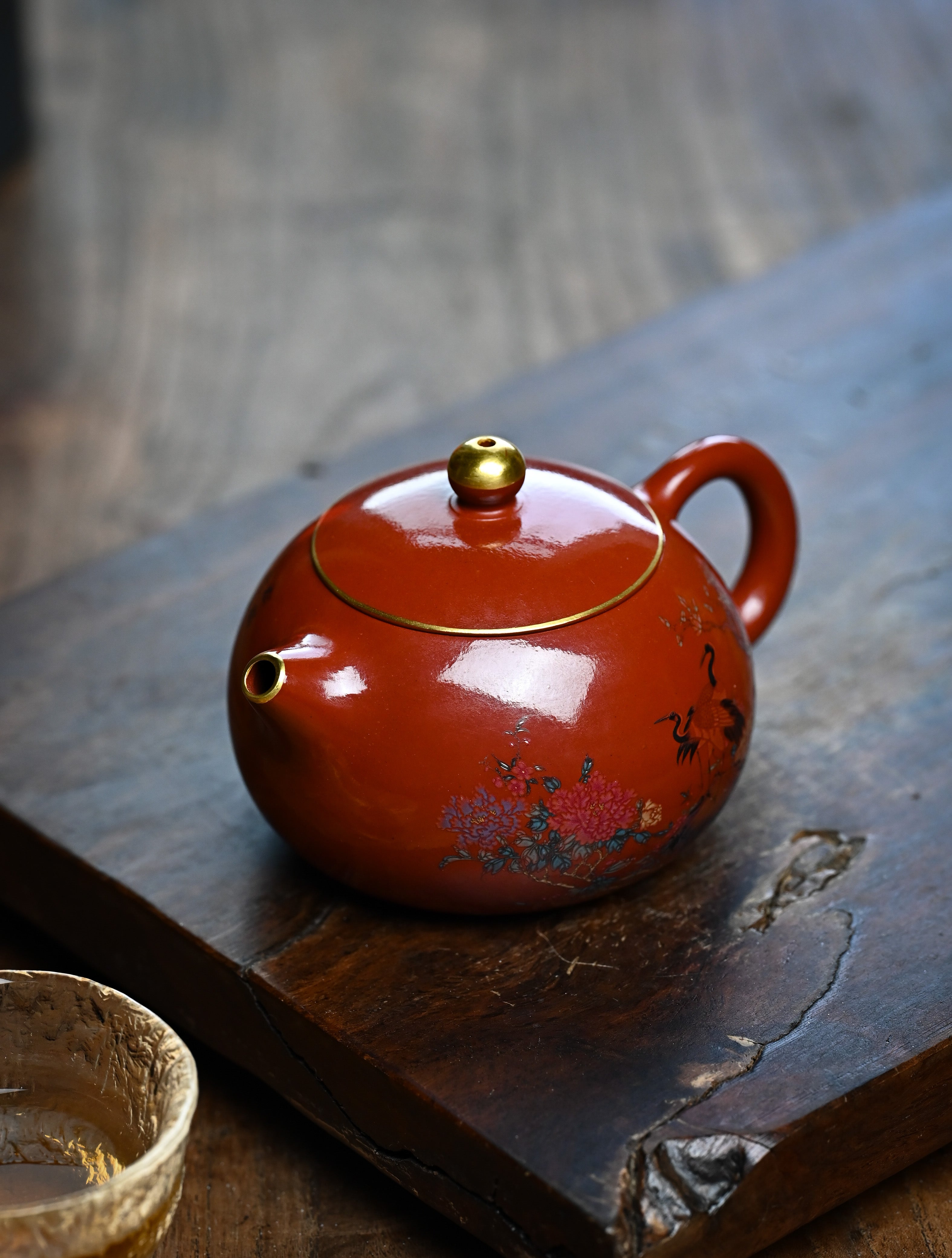 YANYOO handmade Yixing teapot featuring Shuimo polish technique and delicate painting of crane-and-flower motif, lifestyle left side.