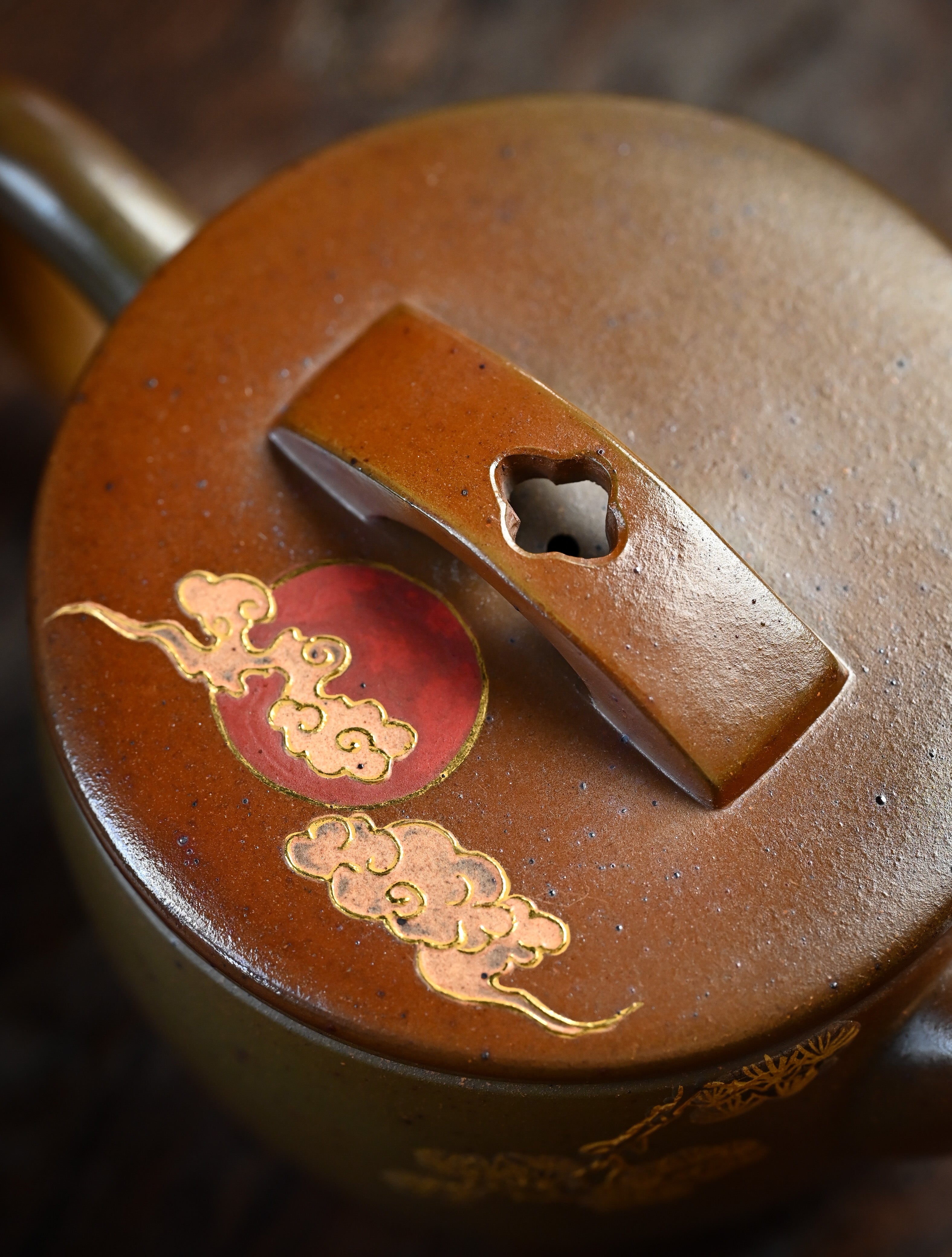 YANYOO handmade wood-fired Yixing teapot featuring hand-painted crane and gold enamel, lifestyle detail top side.