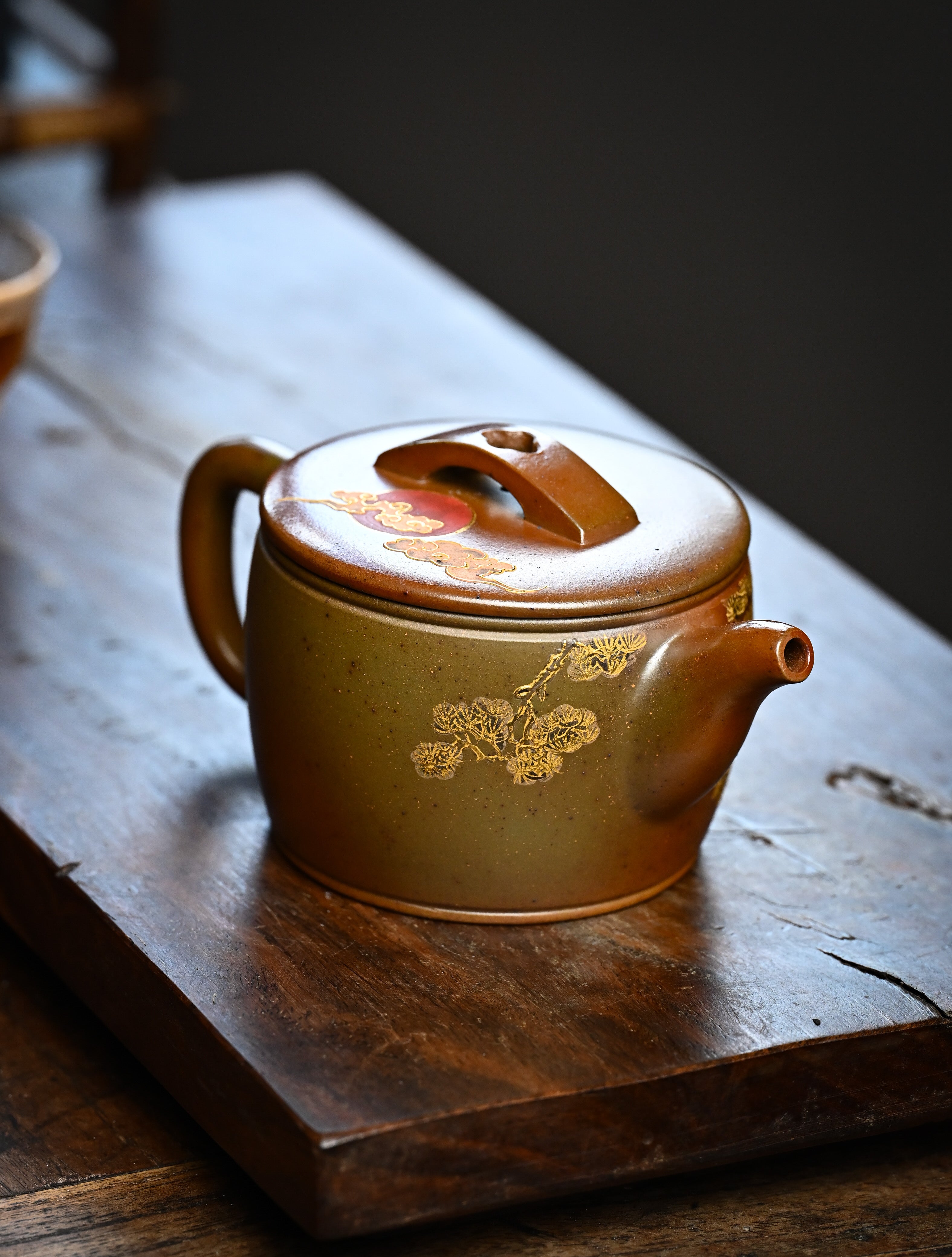 YANYOO handmade wood-fired Yixing teapot featuring hand-painted crane and gold enamel, lifestyle right side.