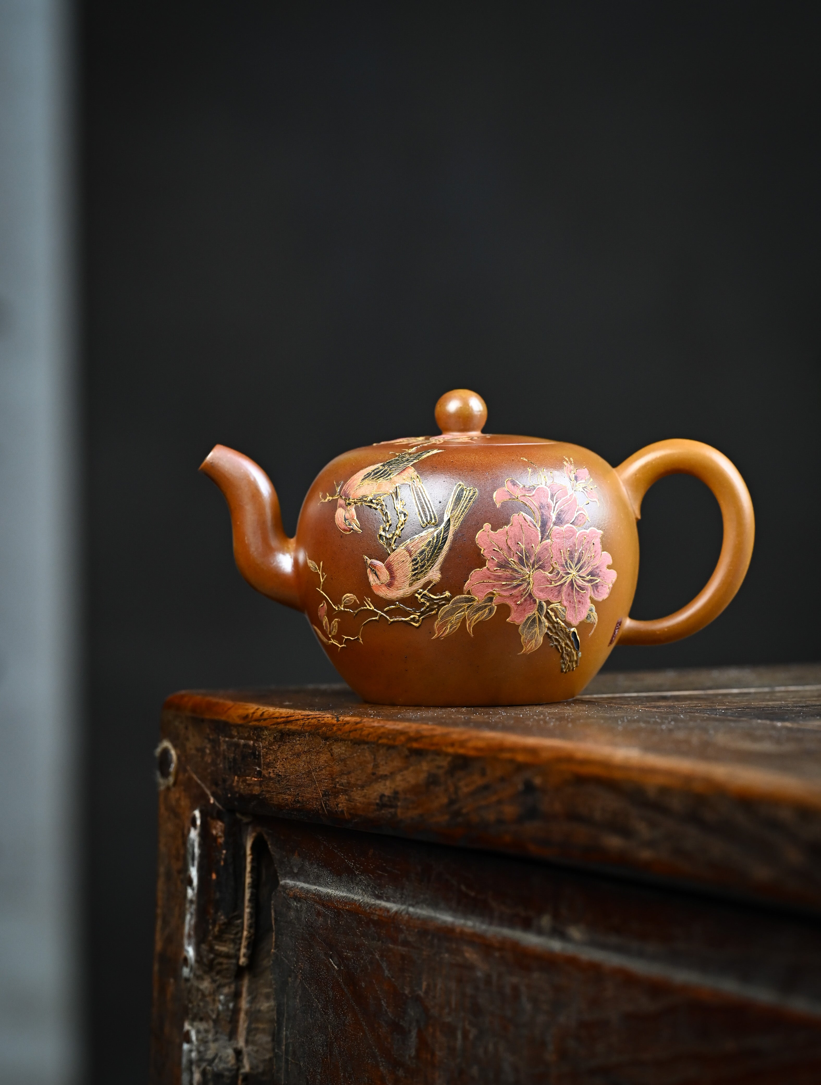 YANYOO handmade wood-fired Yixing teapot featuring hand-painted floral-and-bird motif, lifestyle wide-angle left side.