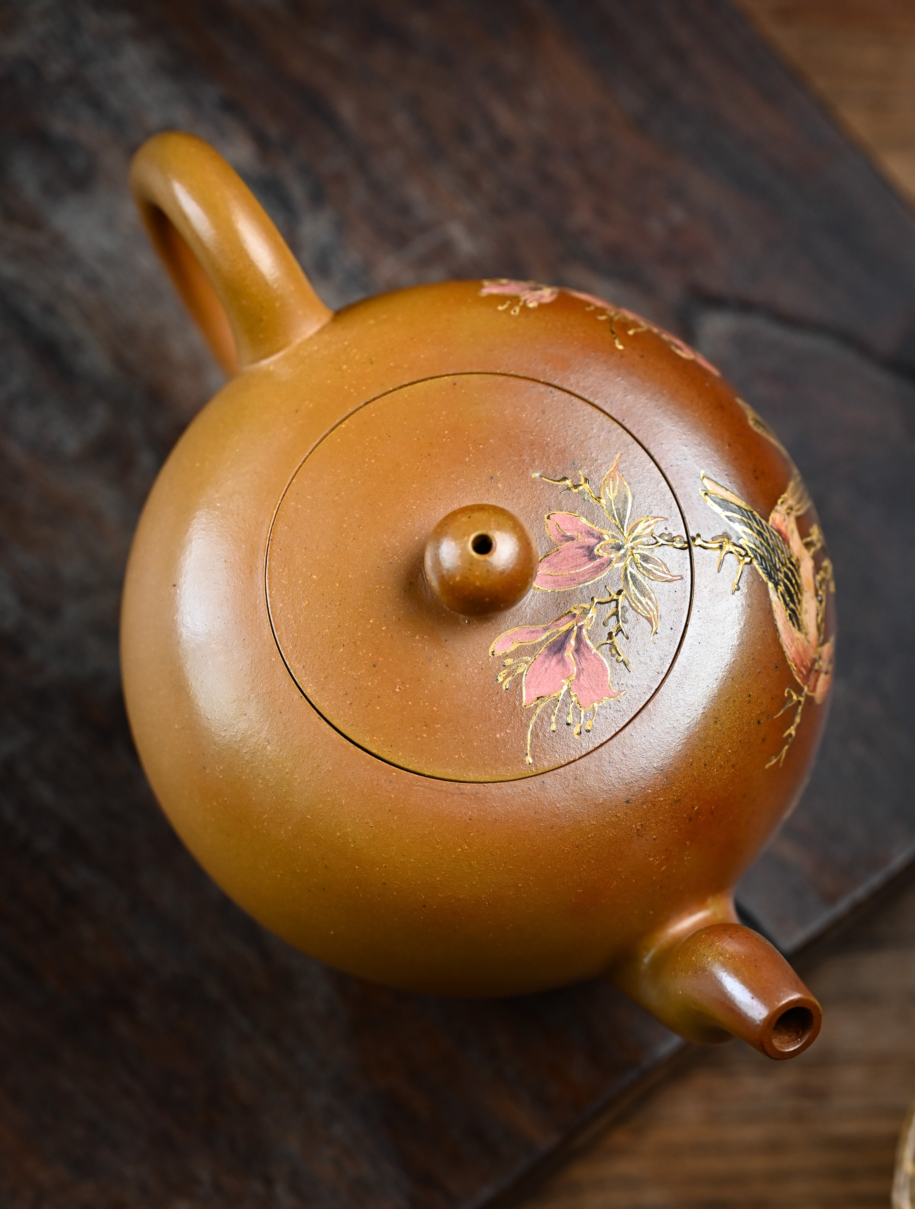 YANYOO handmade wood-fired Yixing teapot featuring hand-painted floral-and-bird motif, lifestyle top side.