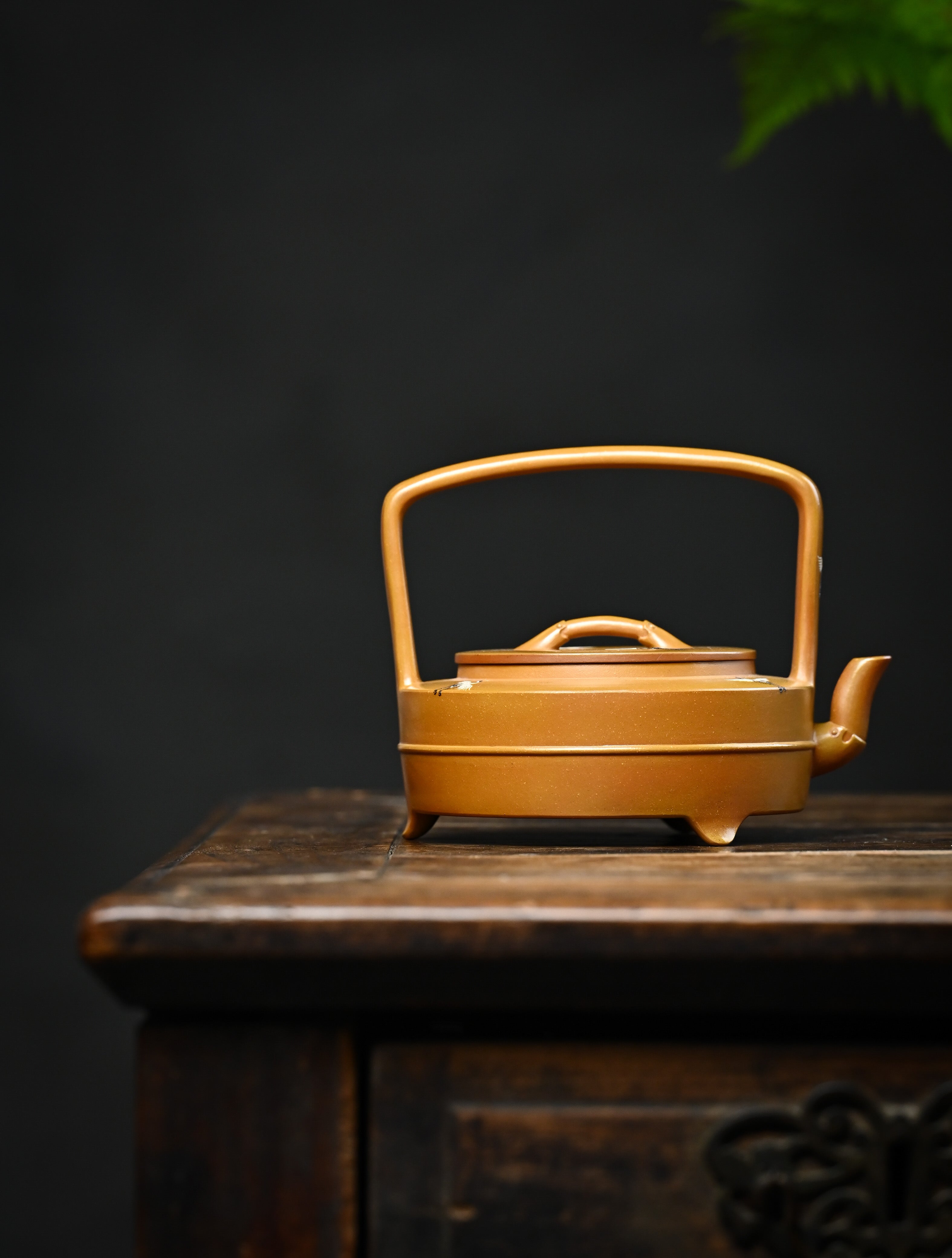 YANYOO handmade wood-fired Yixing teapot featuring hand-painted cloud-and-crane motif and lifting handle, lifestyle wide-angle right side.