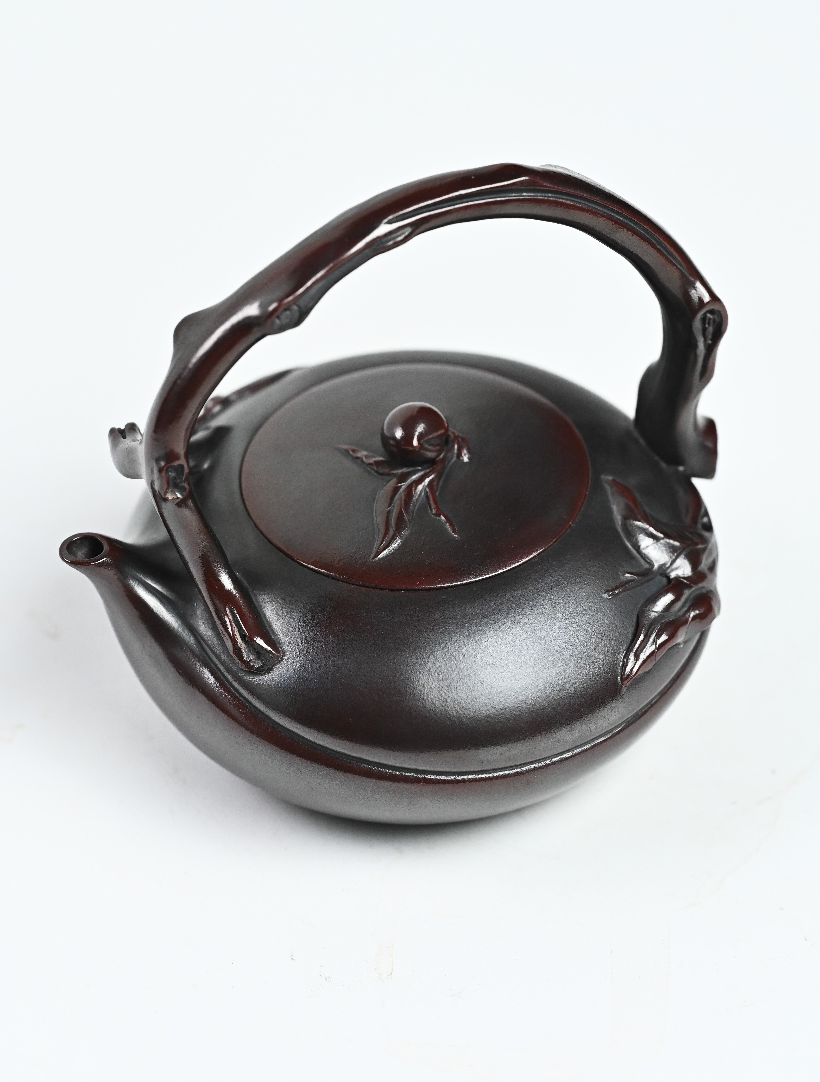 YANYOO handmade Yixing teapot featuring aged Wuni clay, lifting handle and peach sculpture, product top side.
