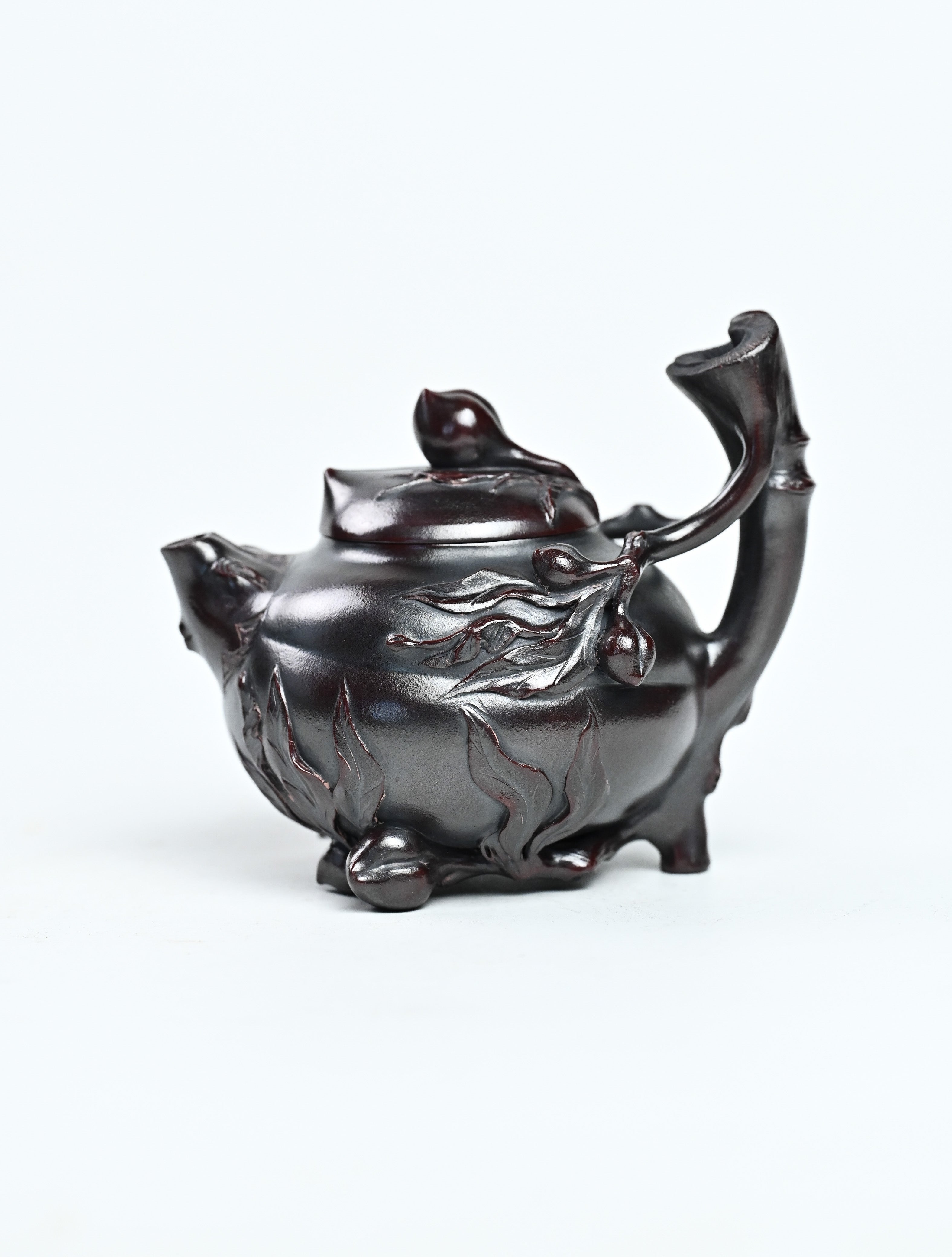 YANYOO handmade Yixing teapot featuring aged Wuni clay and peach sculpture, product left side.
