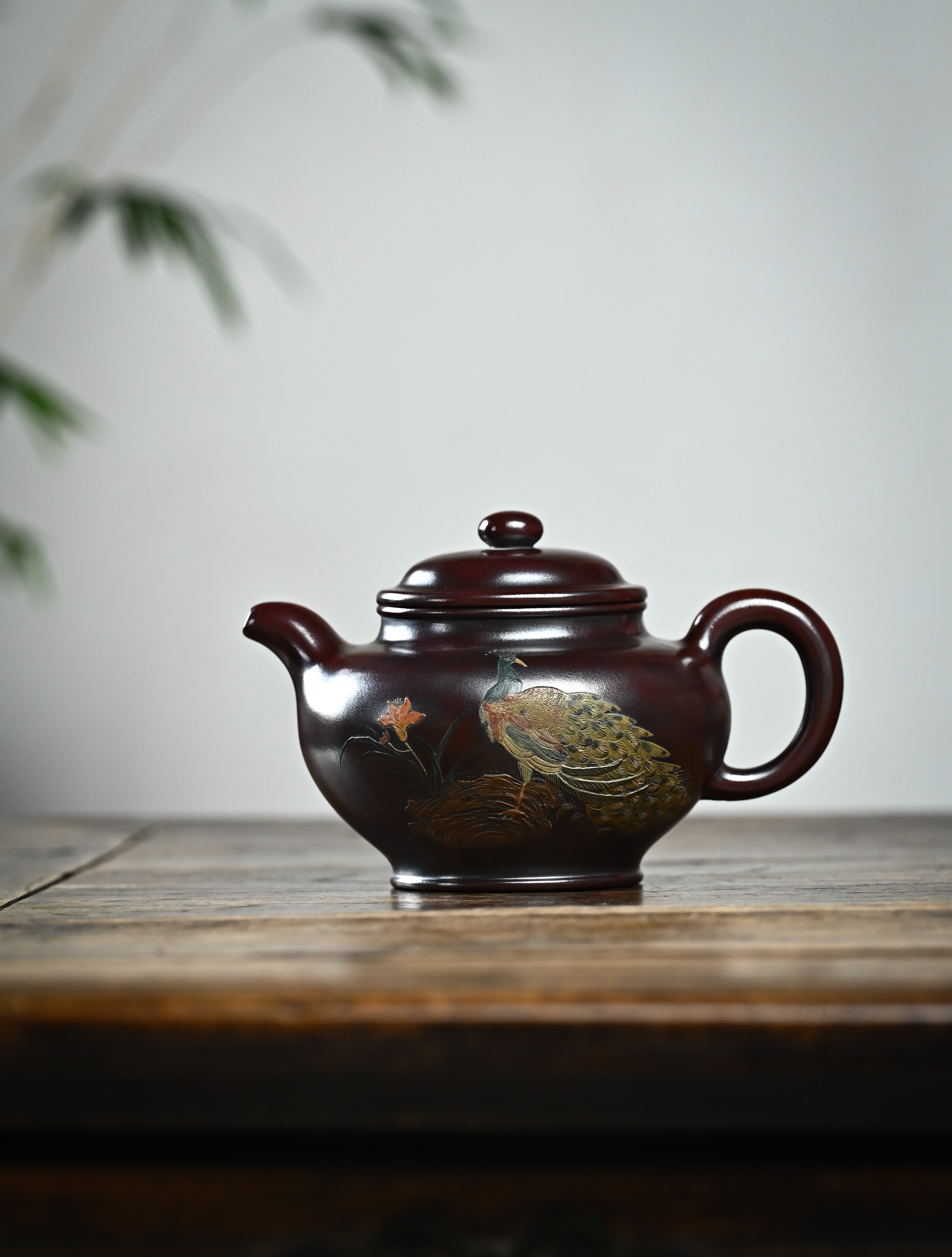YANYOO handmade Yixing teapot featuring aged Wuni clay, peacock clay painting, Duo Zhi, lifestyle wide-angle left side.