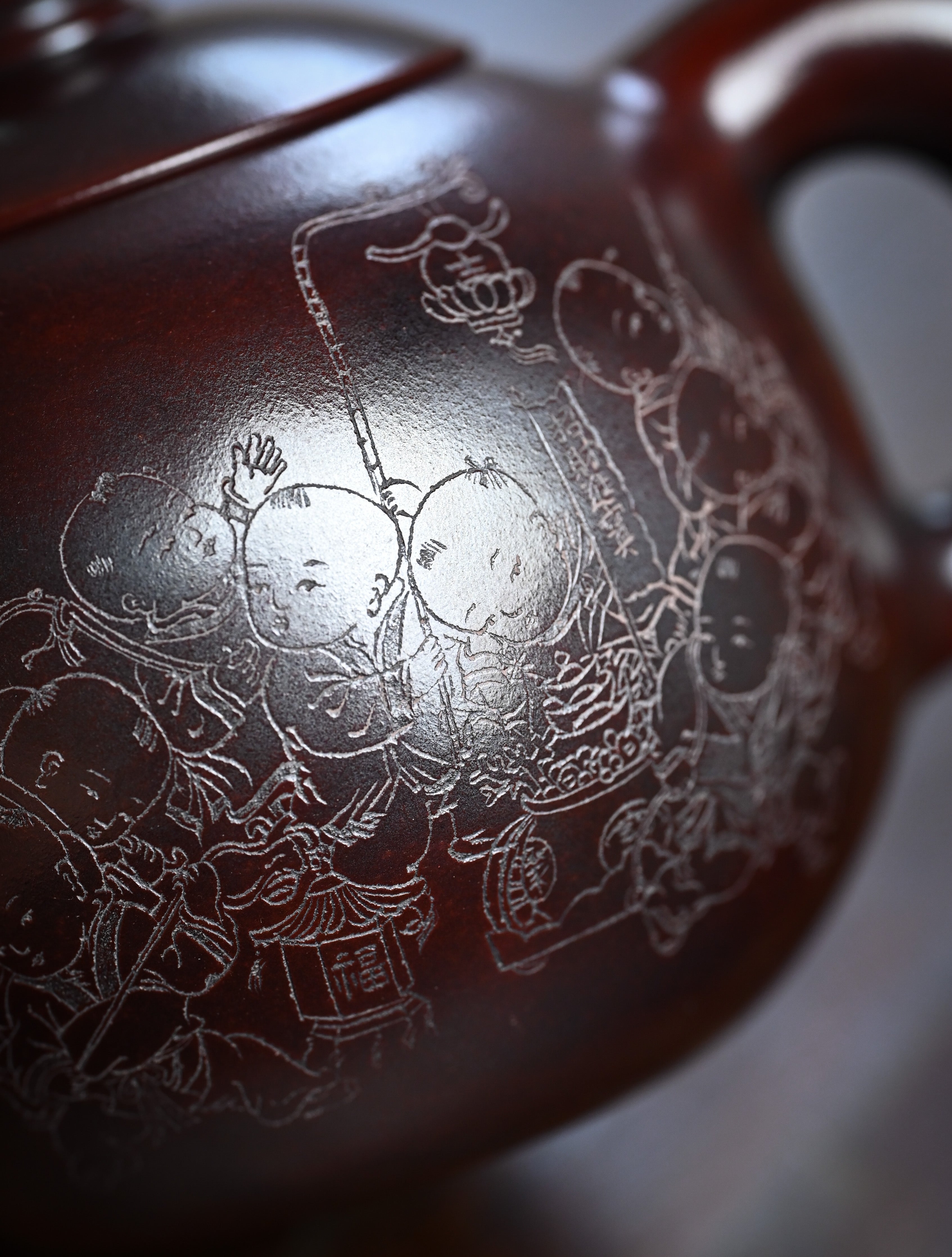 YANYOO handmade Yixing teapot featuring aged Wuni clay and intricate engravings, lifestyle detail front side.
