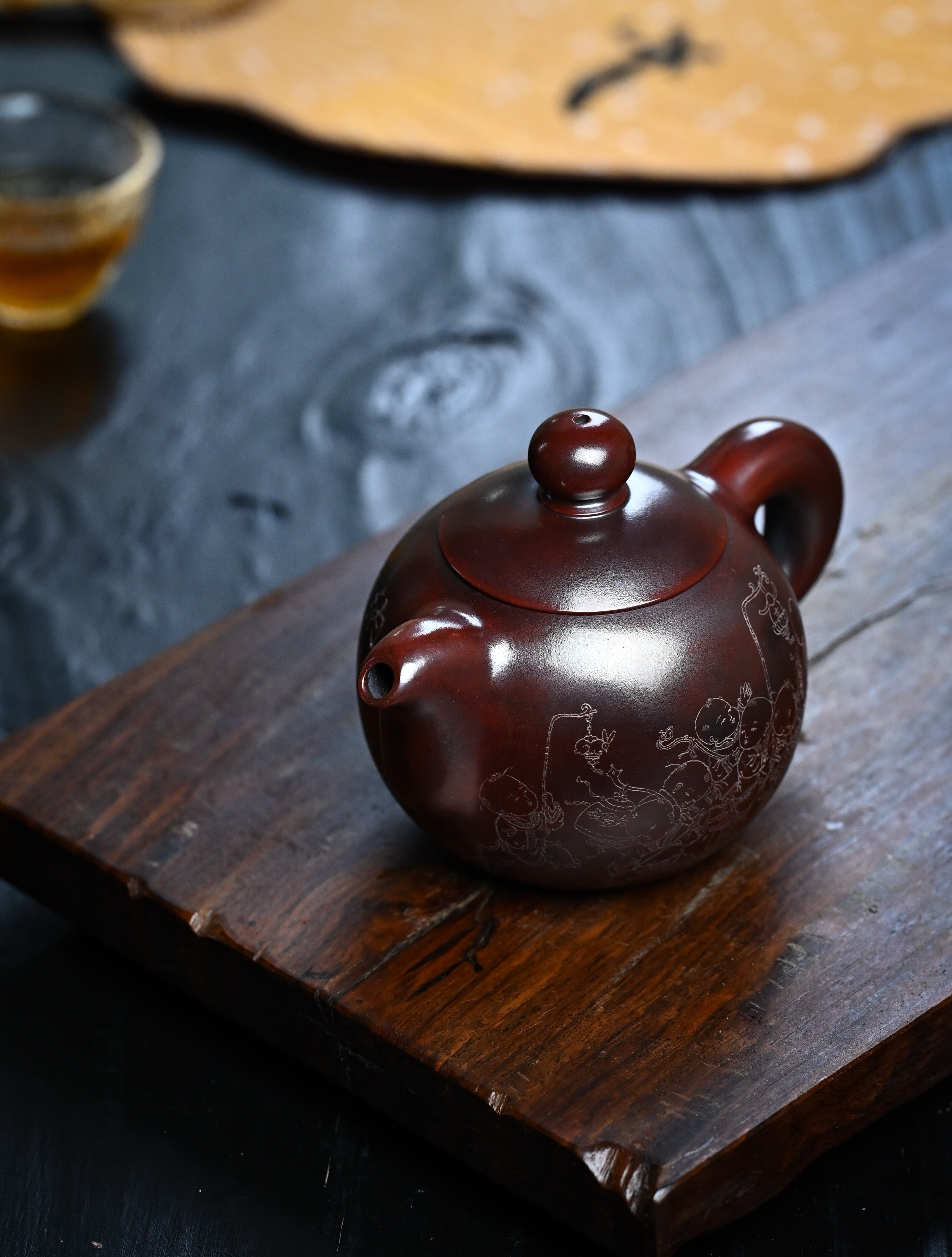 YANYOO handmade Yixing teapot featuring aged Wuni clay and intricate engravings, lifestyle left side.