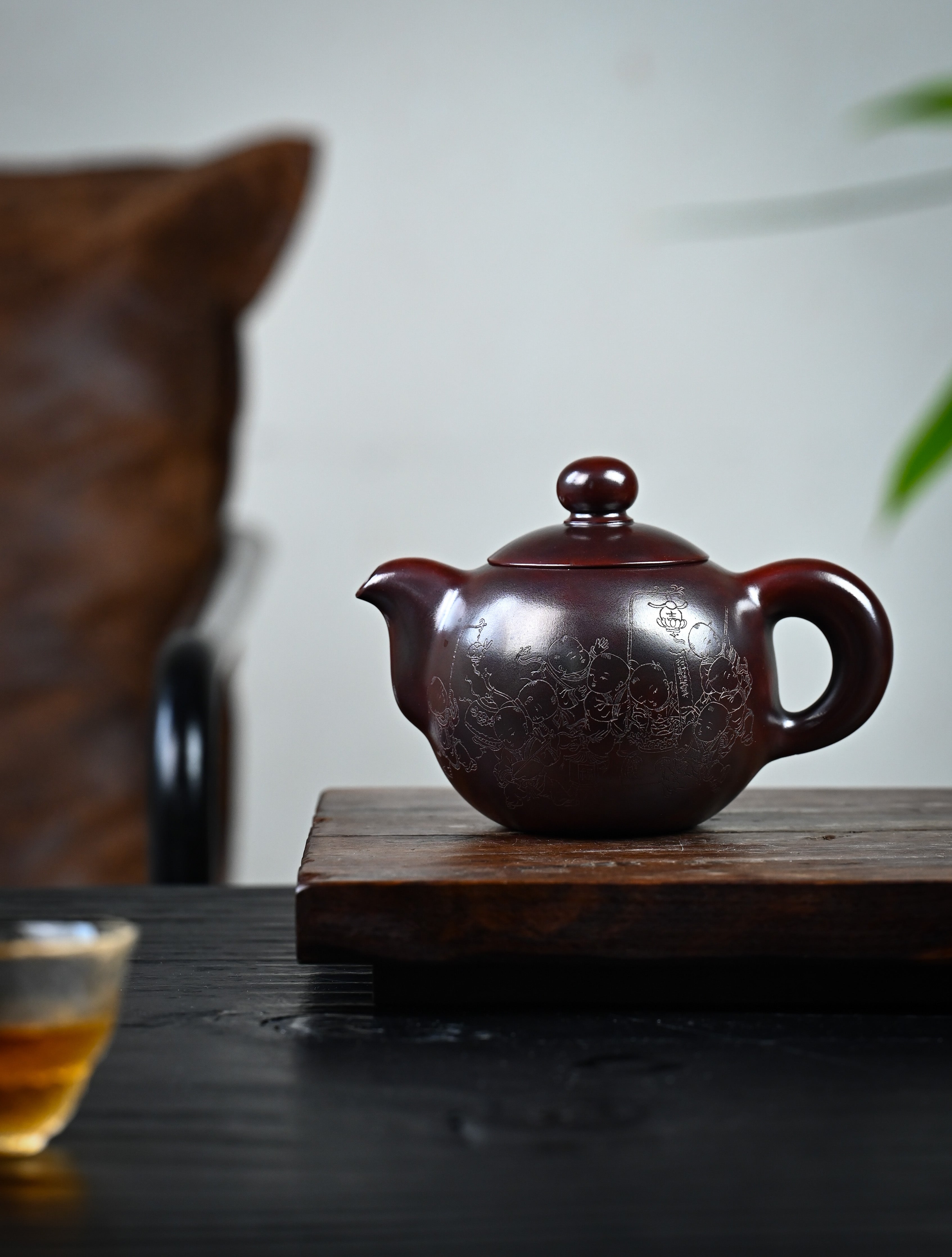YANYOO handmade Yixing teapot featuring aged Wuni clay and intricate engravings, lifestyle wide-angle left side.