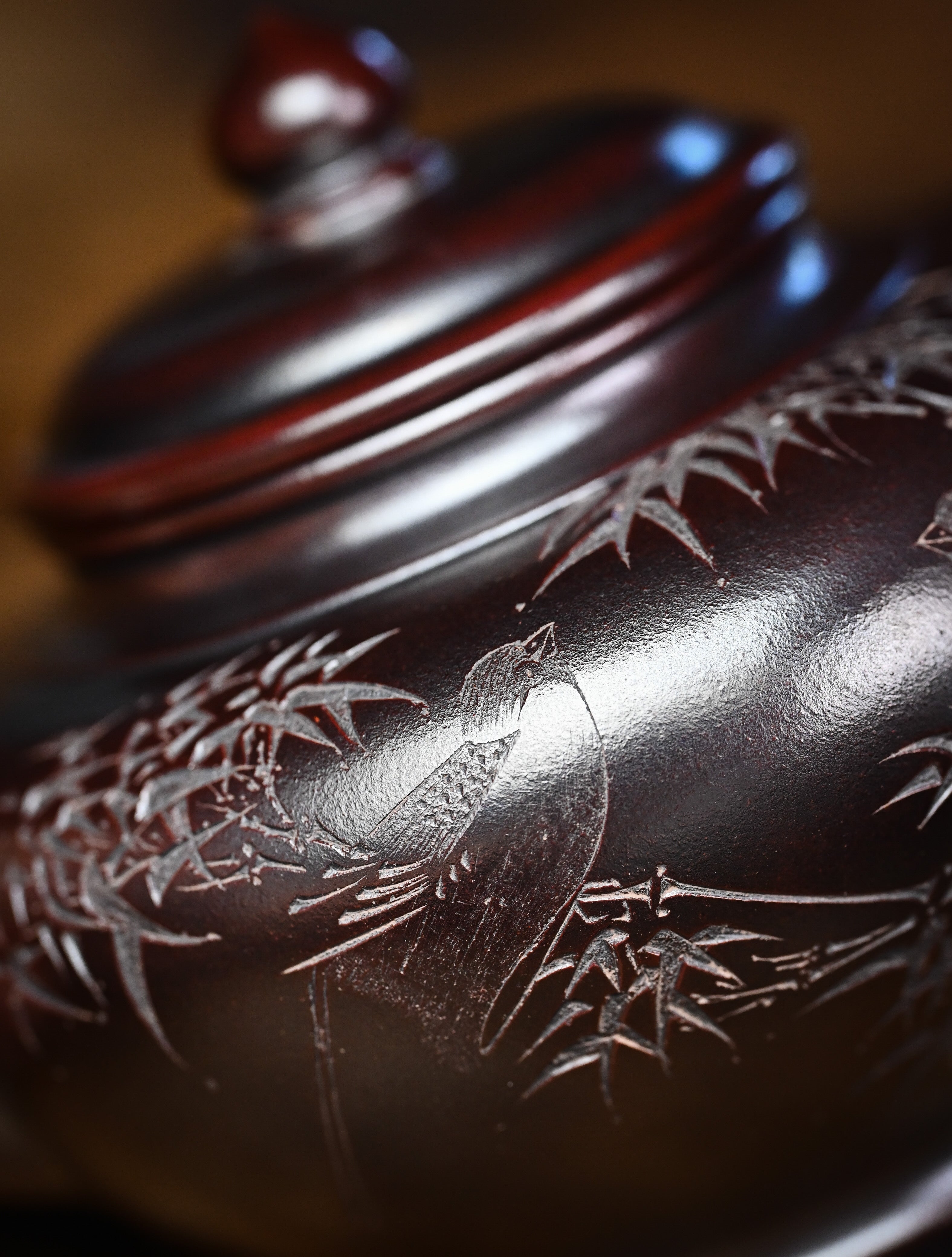YANYOO handmade Yixing teapot featuring aged Wuni clay and bird engravings, lifestyle detail front side.