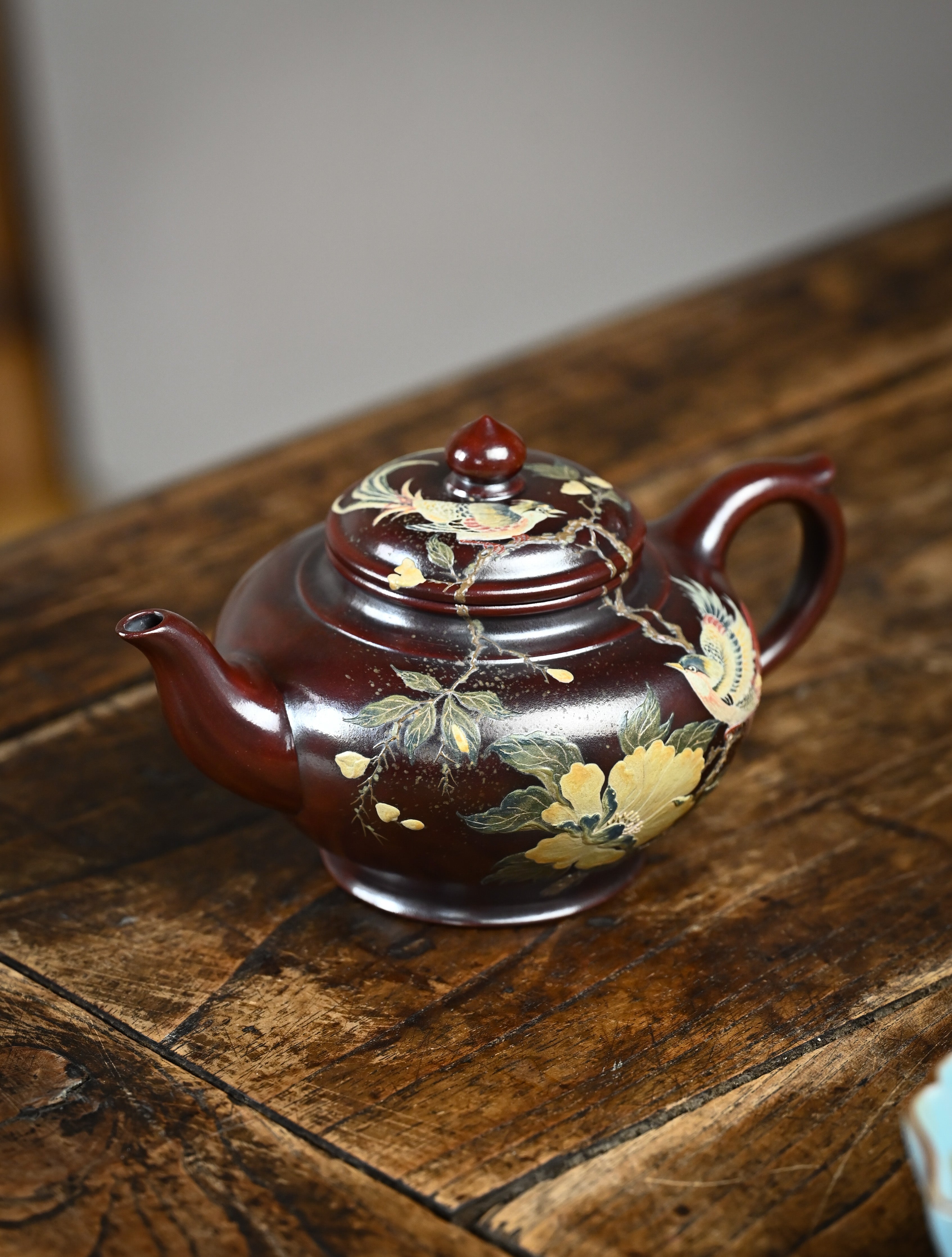 YANYOO handmade Yixing teapot featuring aged Wuni clay, bird-and-flower clay painting, Xiao Ying, lifestyle left side.