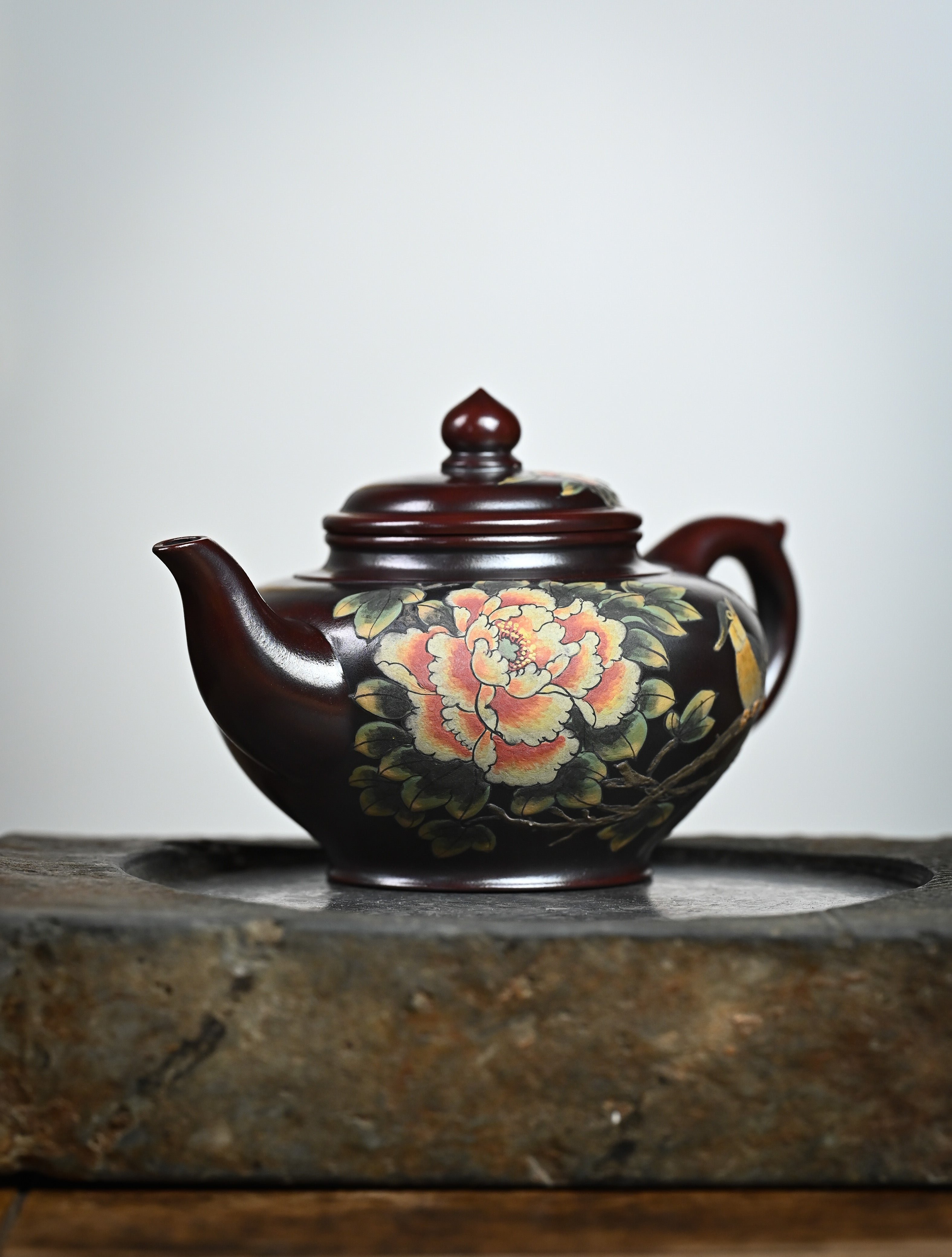 YANYOO handmade Yixing teapot featuring aged Wuni clay and bird-and-flower painting, lifestyle front side.
