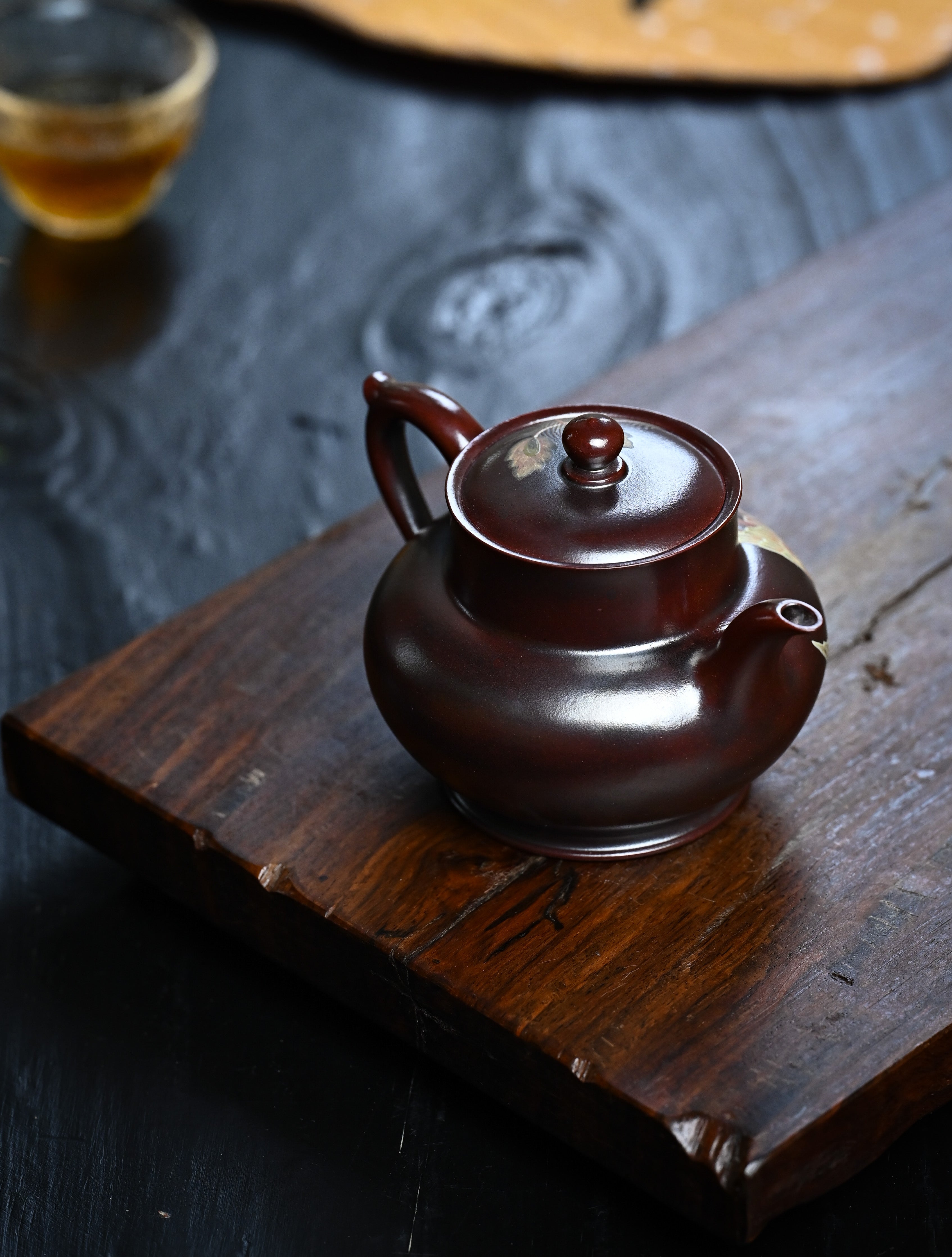 YANYOO handmade Yixing teapot featuring aged Wuni clay and phoenix-and-cloud painting, lifestyle right side.