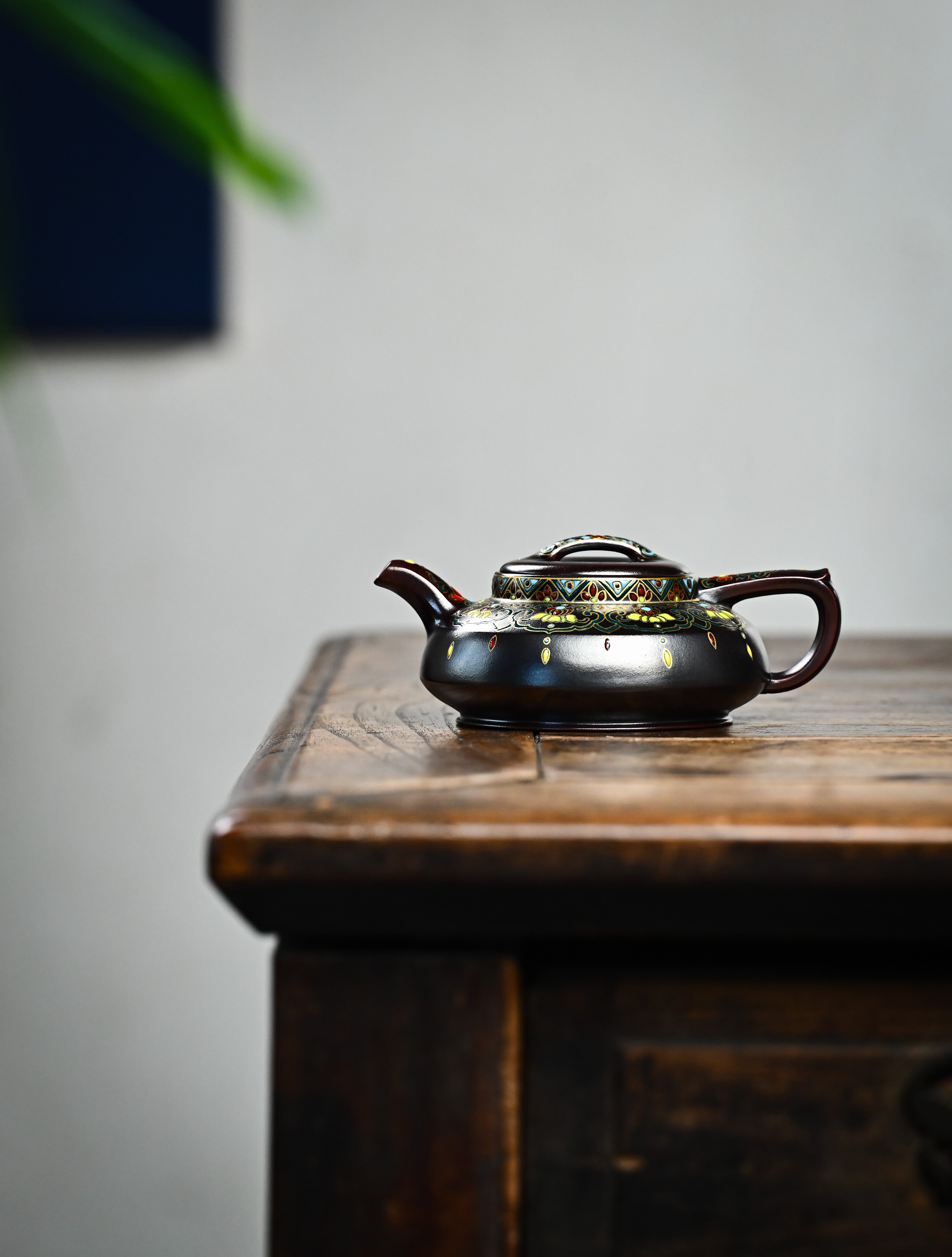 YANYOO handmade Yixing teapot featuring aged Wuni clay and delicate Falangcai, lifestyle wide-angle left side.