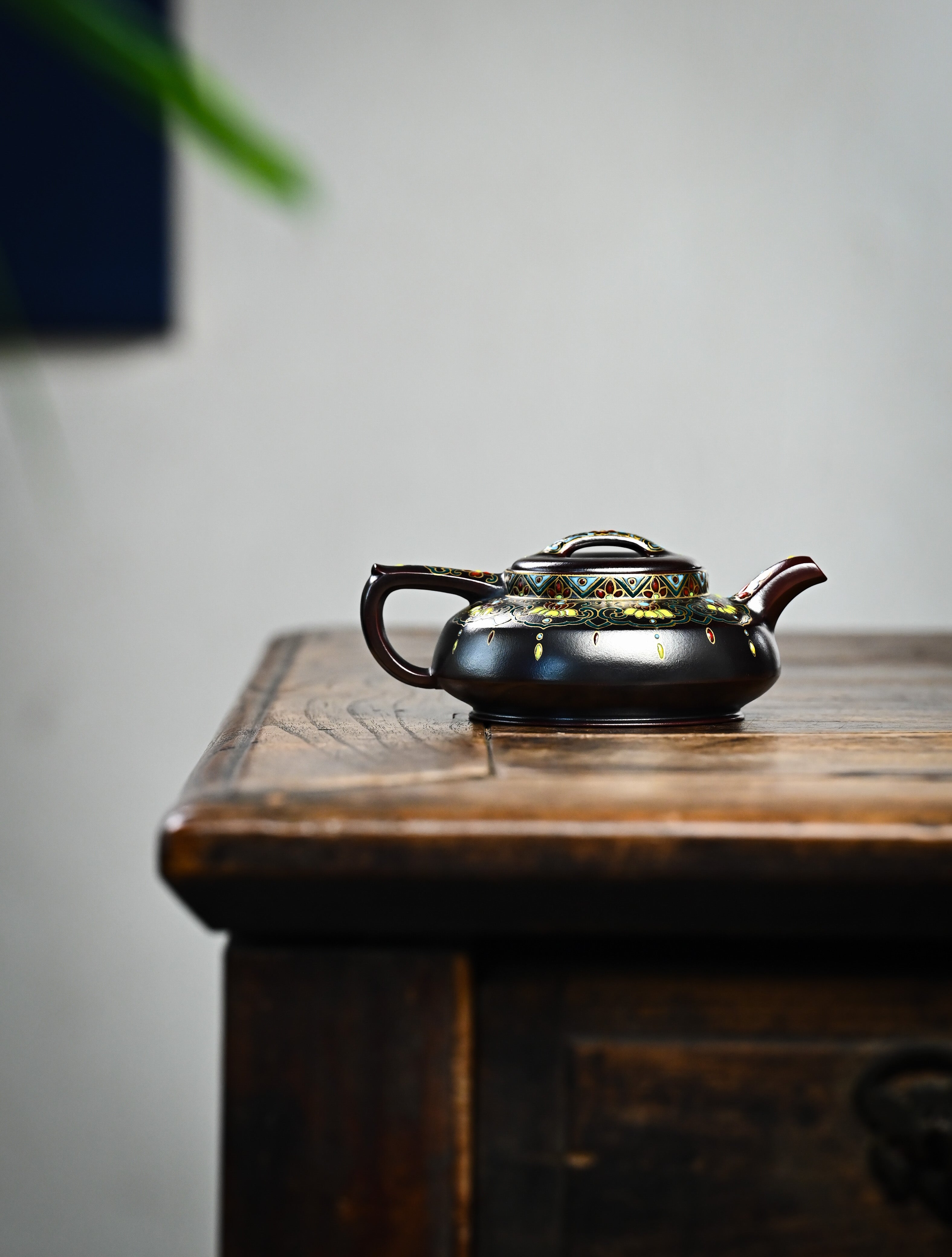 YANYOO handmade Yixing teapot featuring aged Wuni clay and delicate Falangcai, lifestyle wide-angle right side.